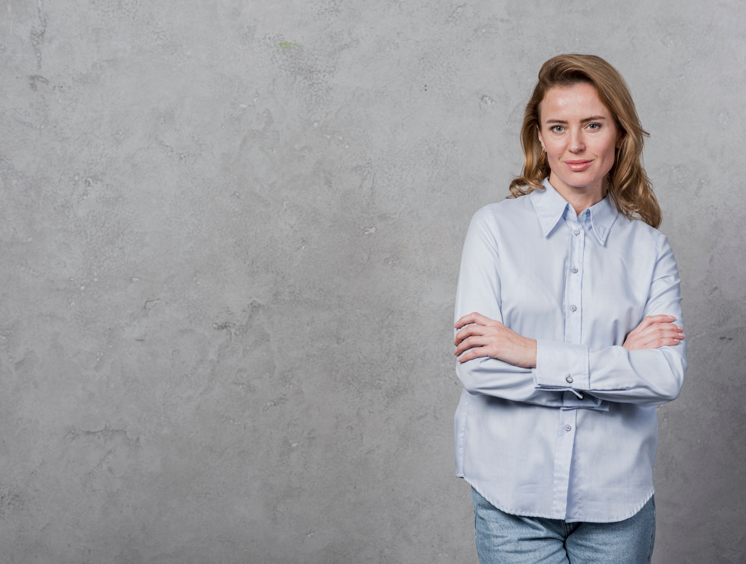 Eine lächelnde Frau mit verschränkten Armen | Quelle: Freepik