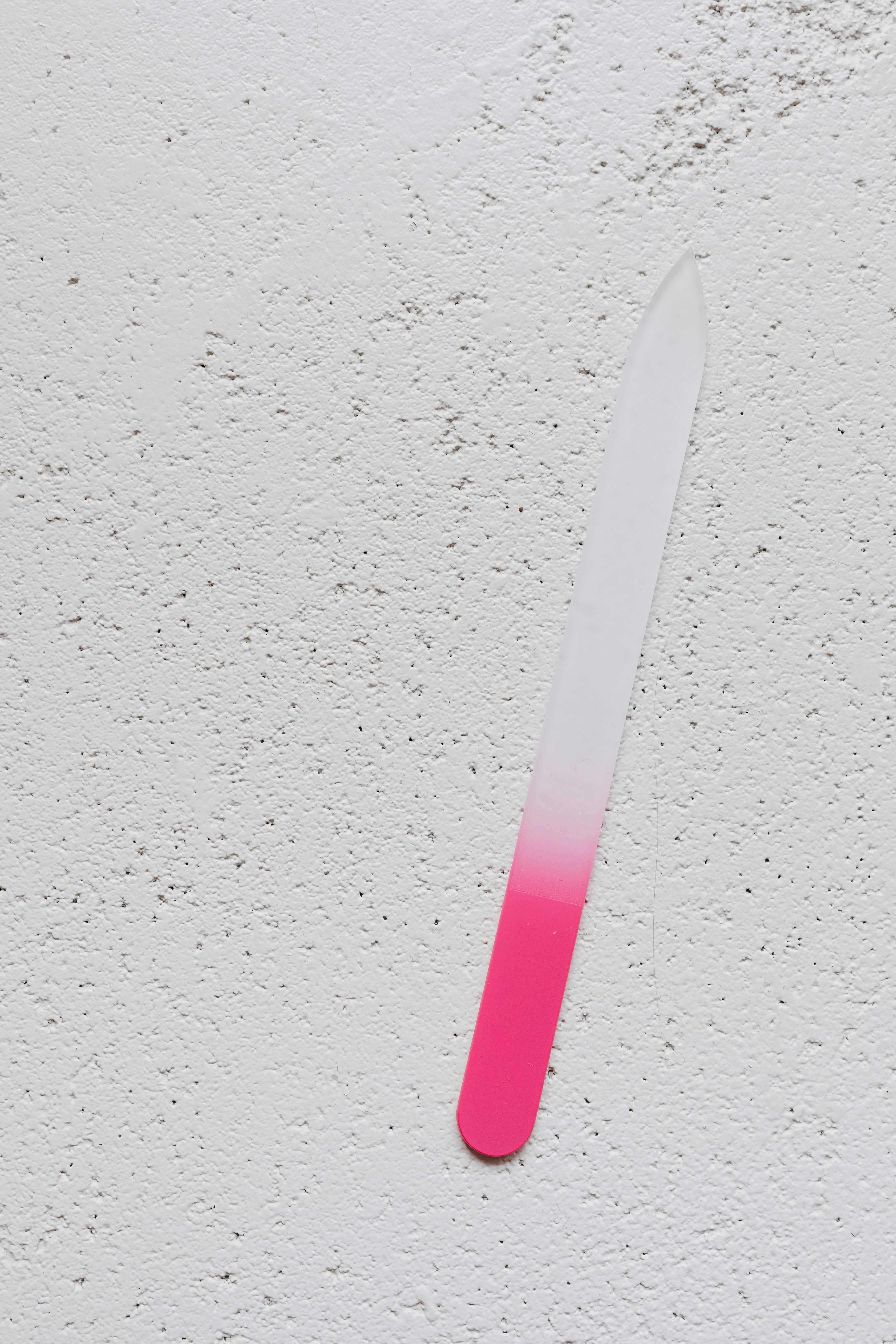 Eine rosa und weiße Nagelfeile auf einem Tisch | Quelle: Pexels