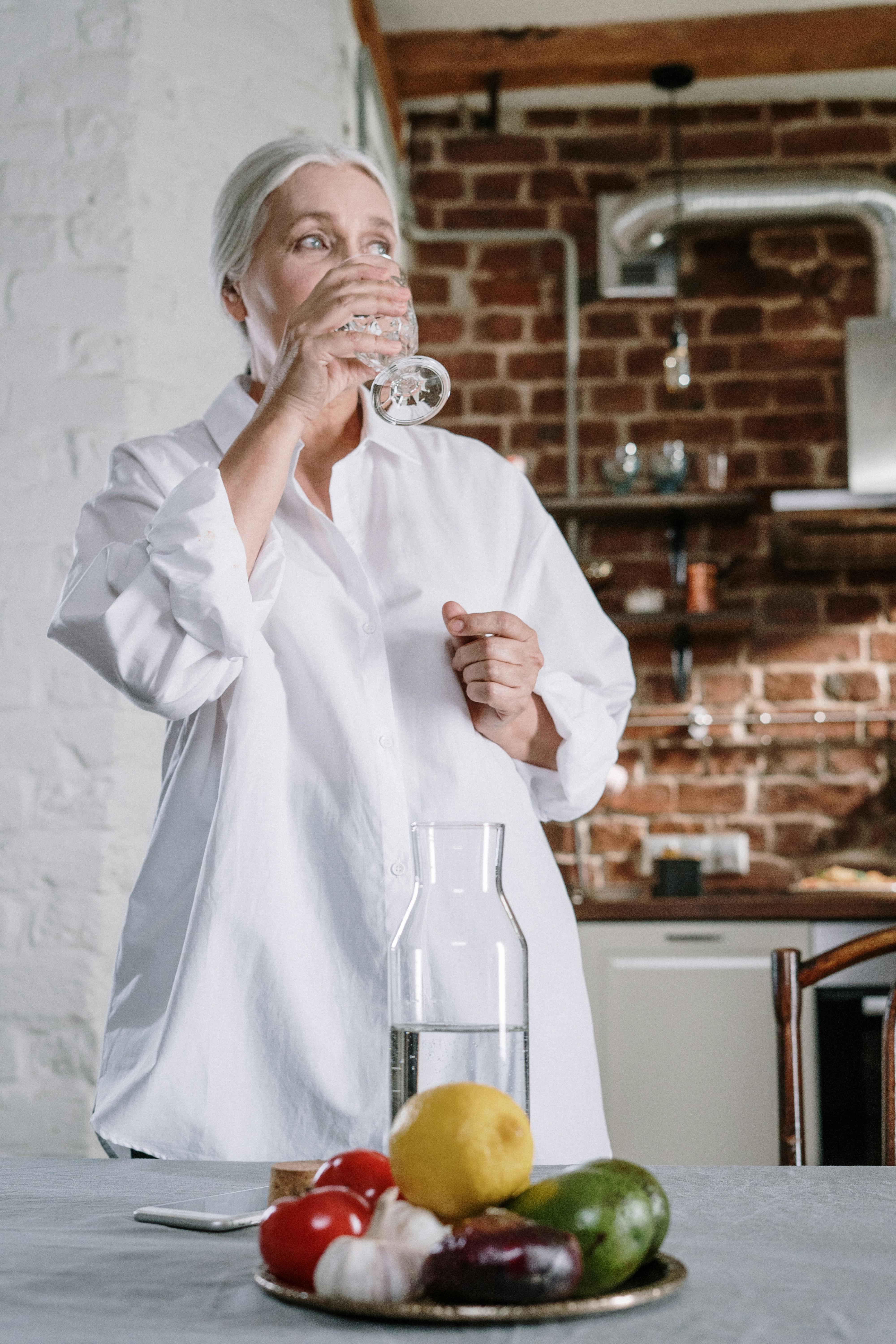 Eine ältere Frau trinkt ein Glas Wasser | Quelle: Pexels