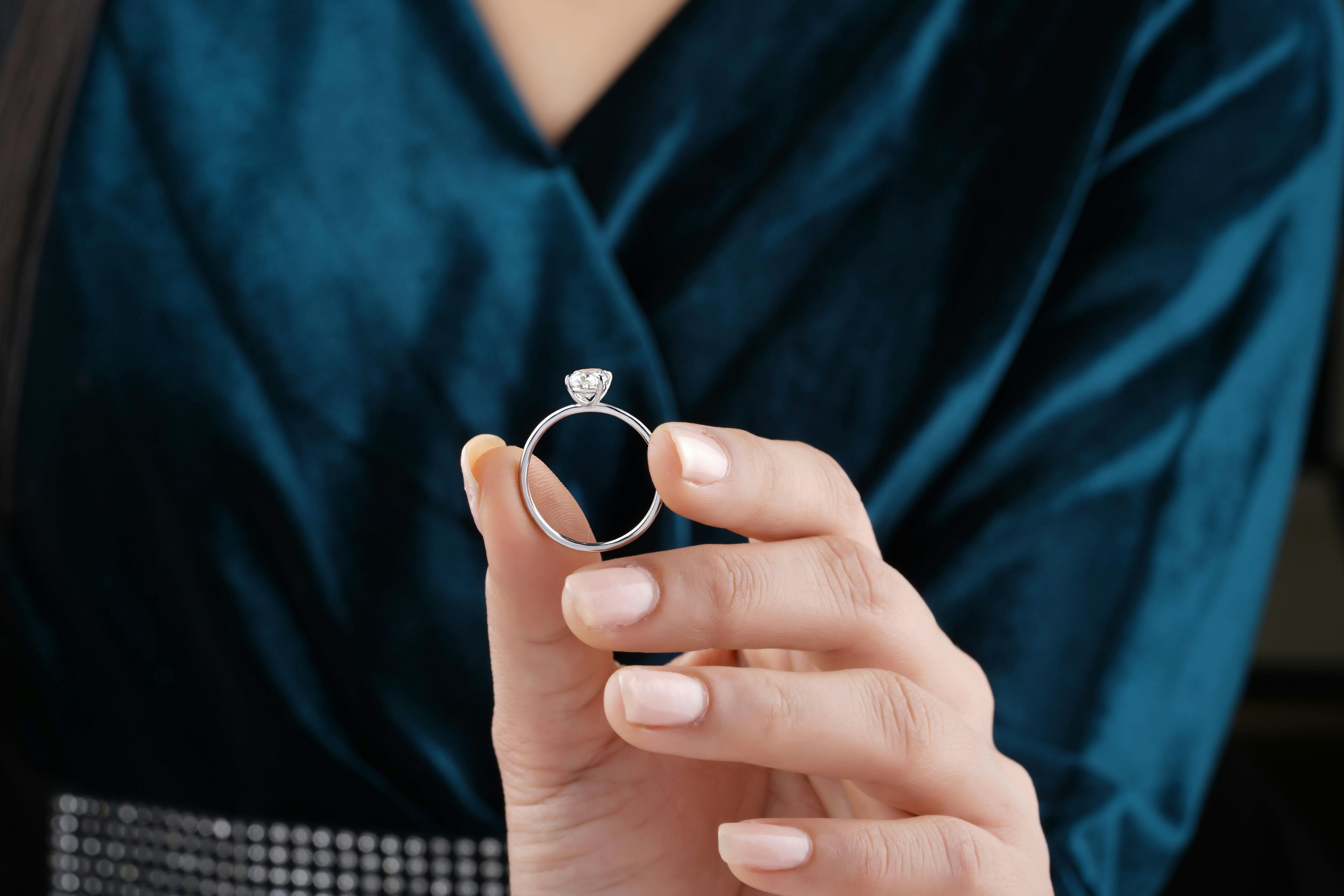 Eine Frau hält einen Diamantring | Quelle: Pexels