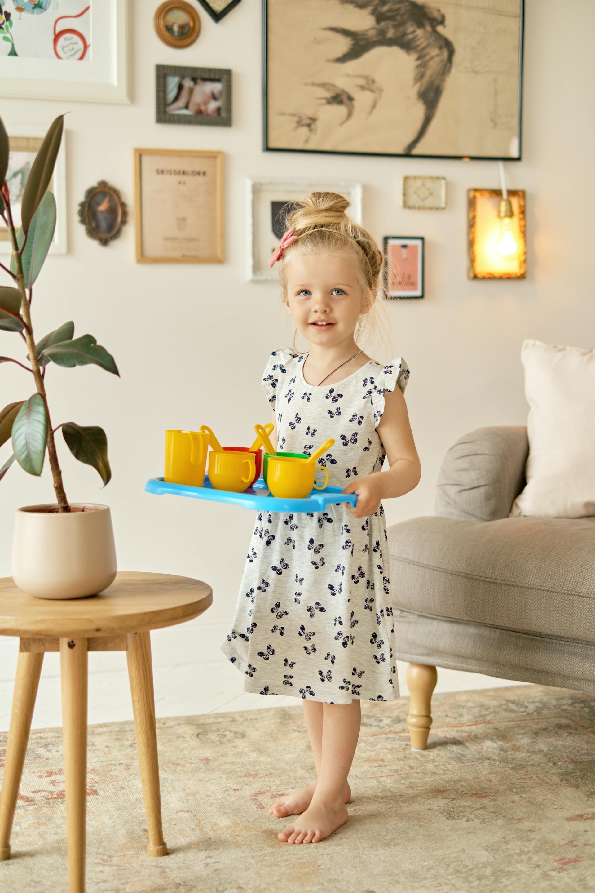 Ein junges Mädchen trägt Plastikbecher auf einem Plastiktablett | Quelle: Pexels