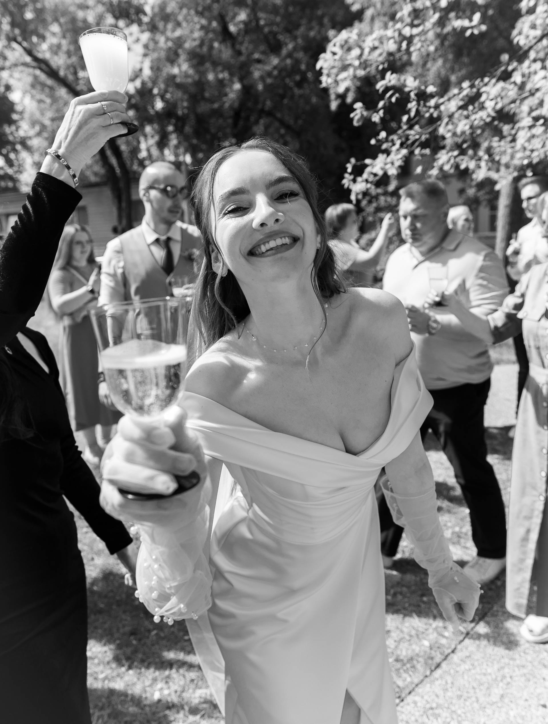 Graustufenaufnahme einer lächelnden Braut mit einem Getränk in der Hand | Quelle: Pexels