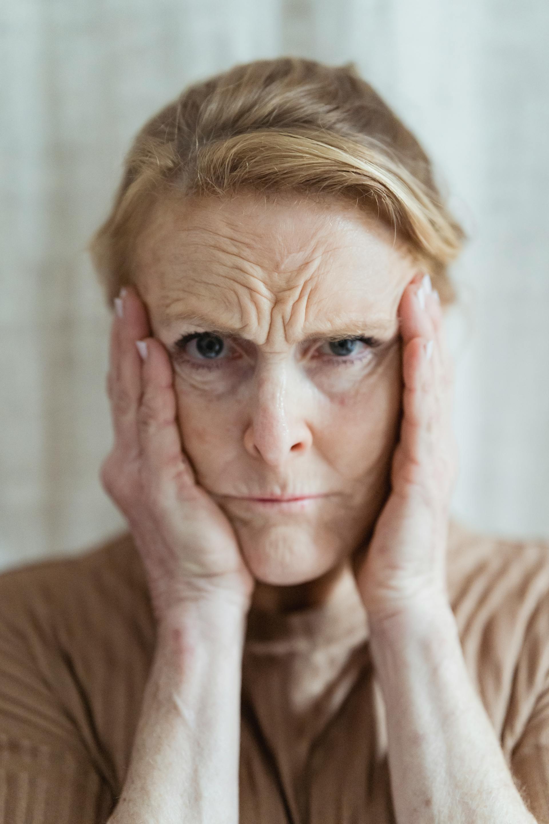 Eine besorgt dreinblickende Frau, die sich die Schläfen reibt | Quelle: Pexels