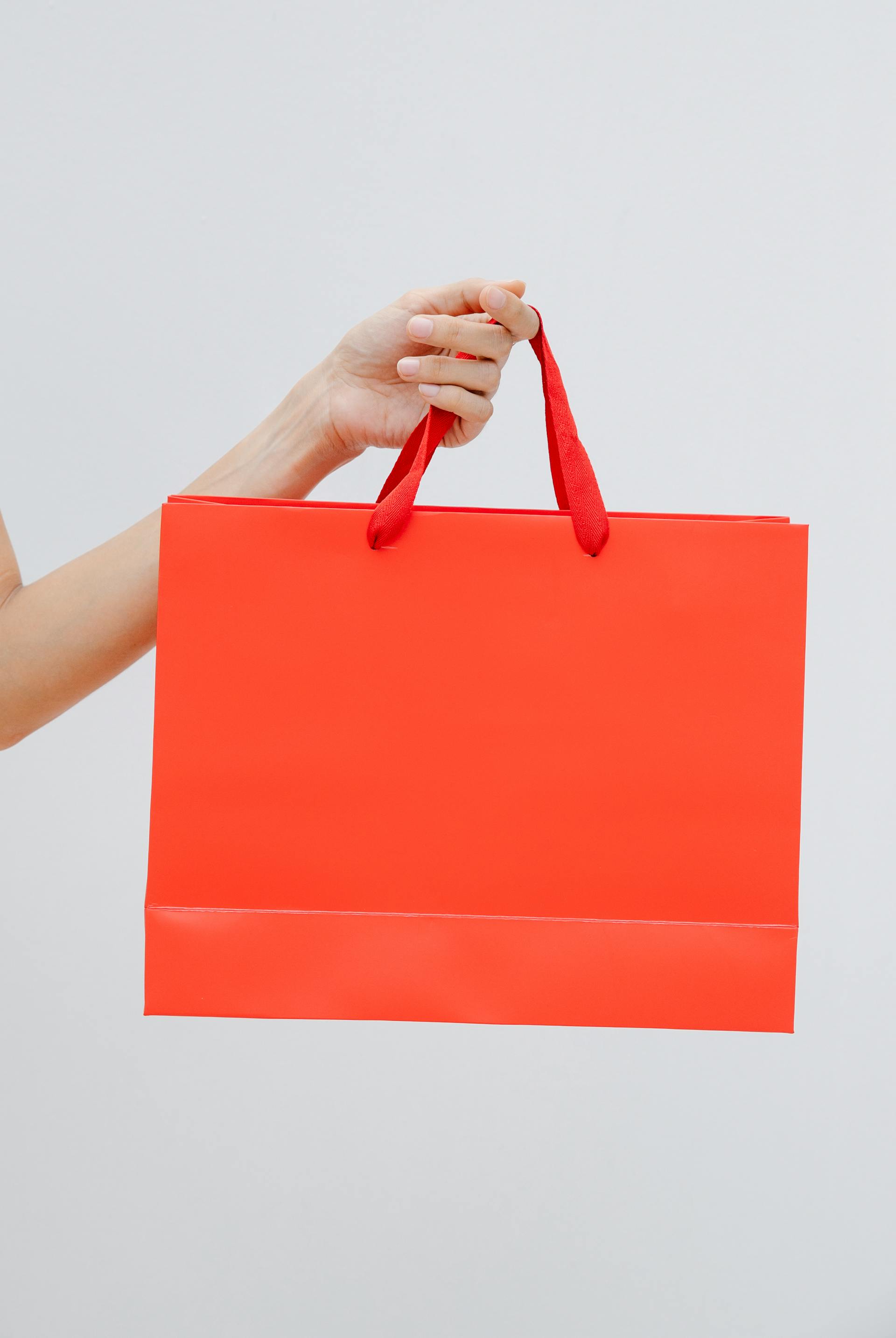 Eine Frau hält eine Geschenktüte | Quelle: Pexels