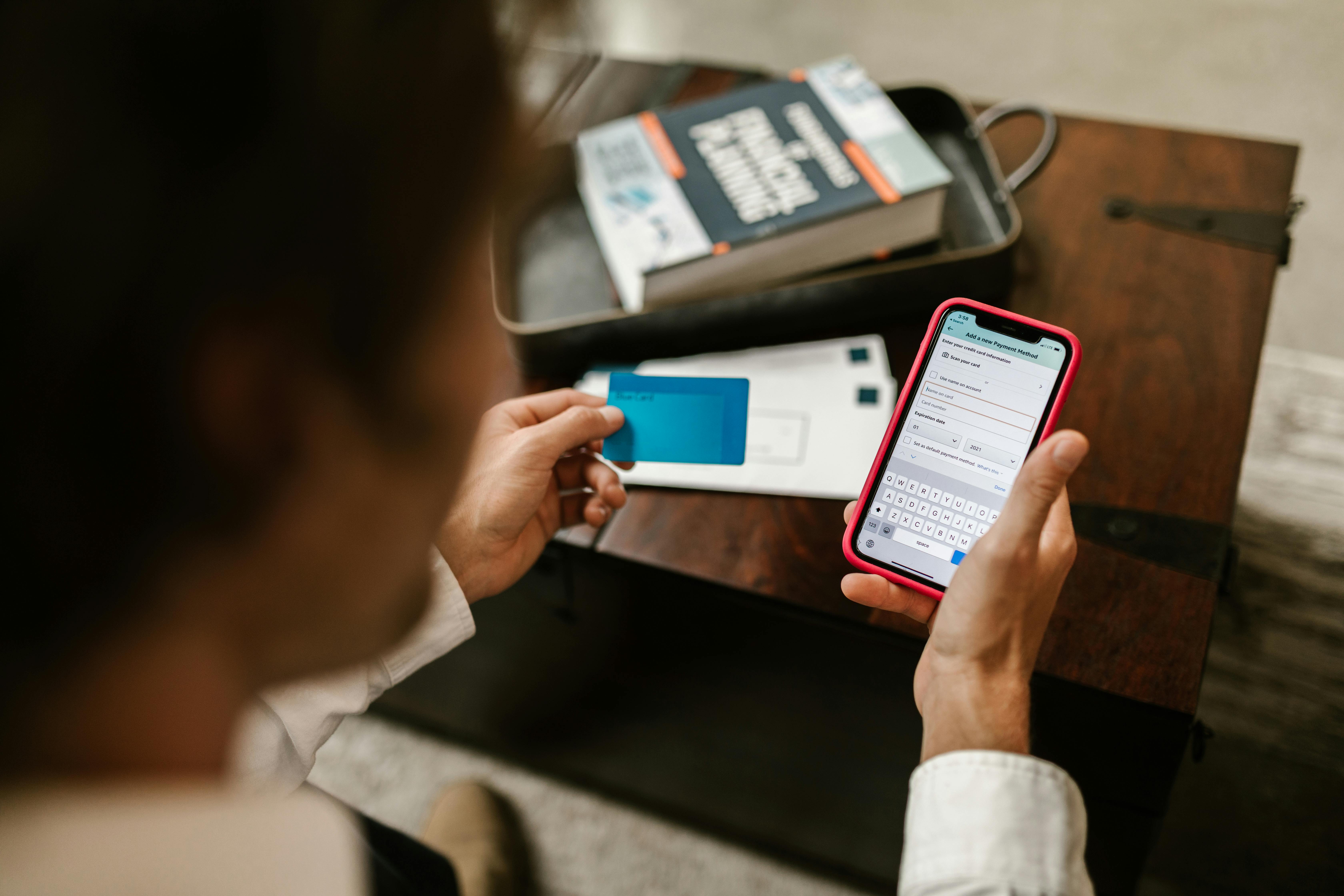 Eine Person hält eine Bankkarte und ein Handy in der Hand | Quelle: Pexels
