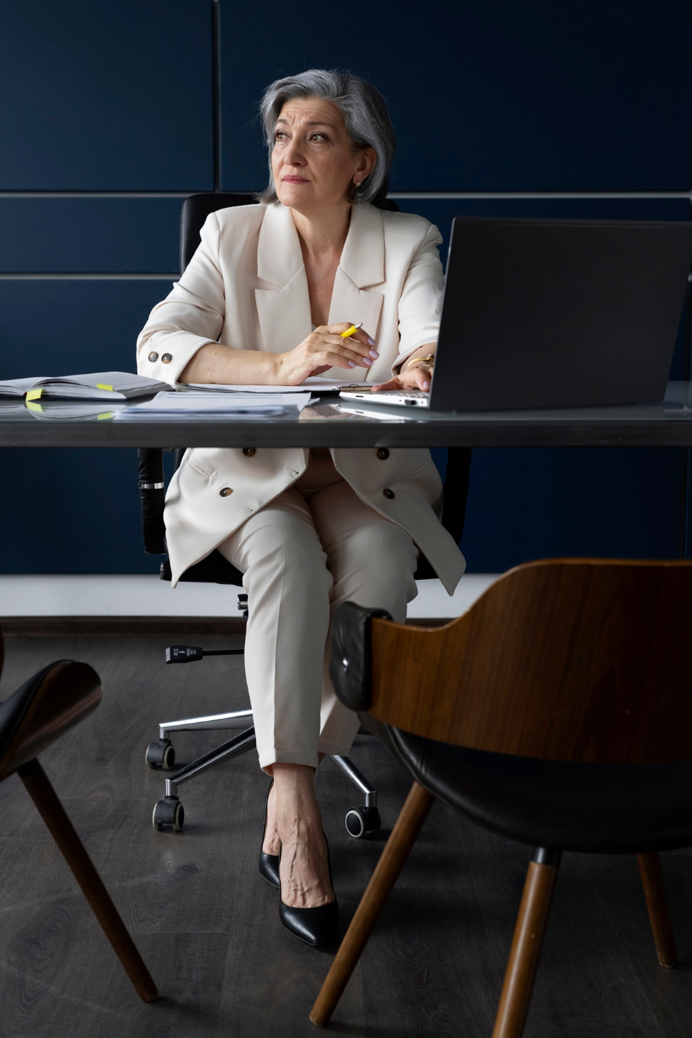 Eine ältere Frau, die in ihrem Büro sitzt | Quelle: Freepik