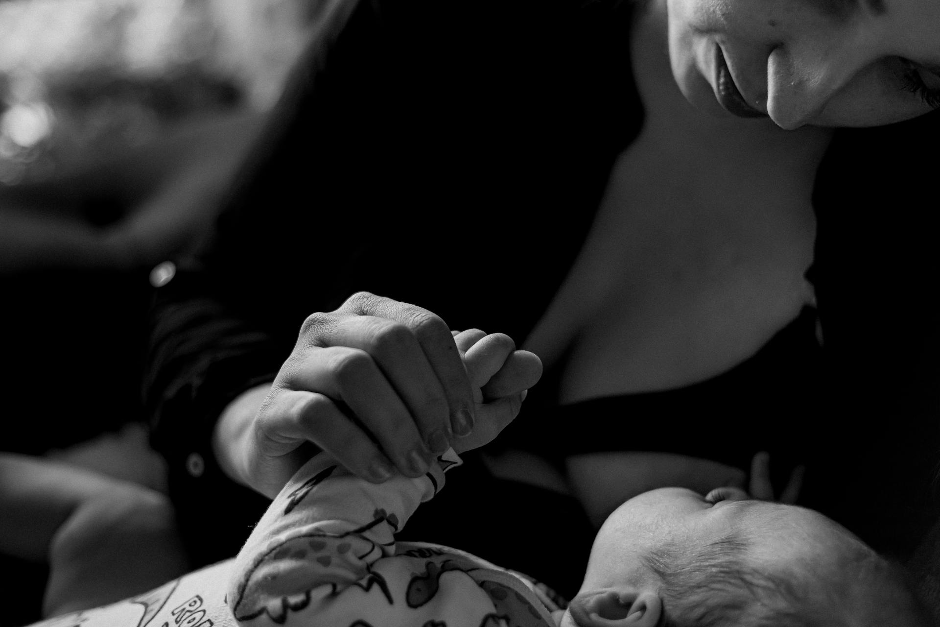 Ein Graustufenfoto von einer Frau, die ihr Baby im Arm hält | Quelle: Pexels