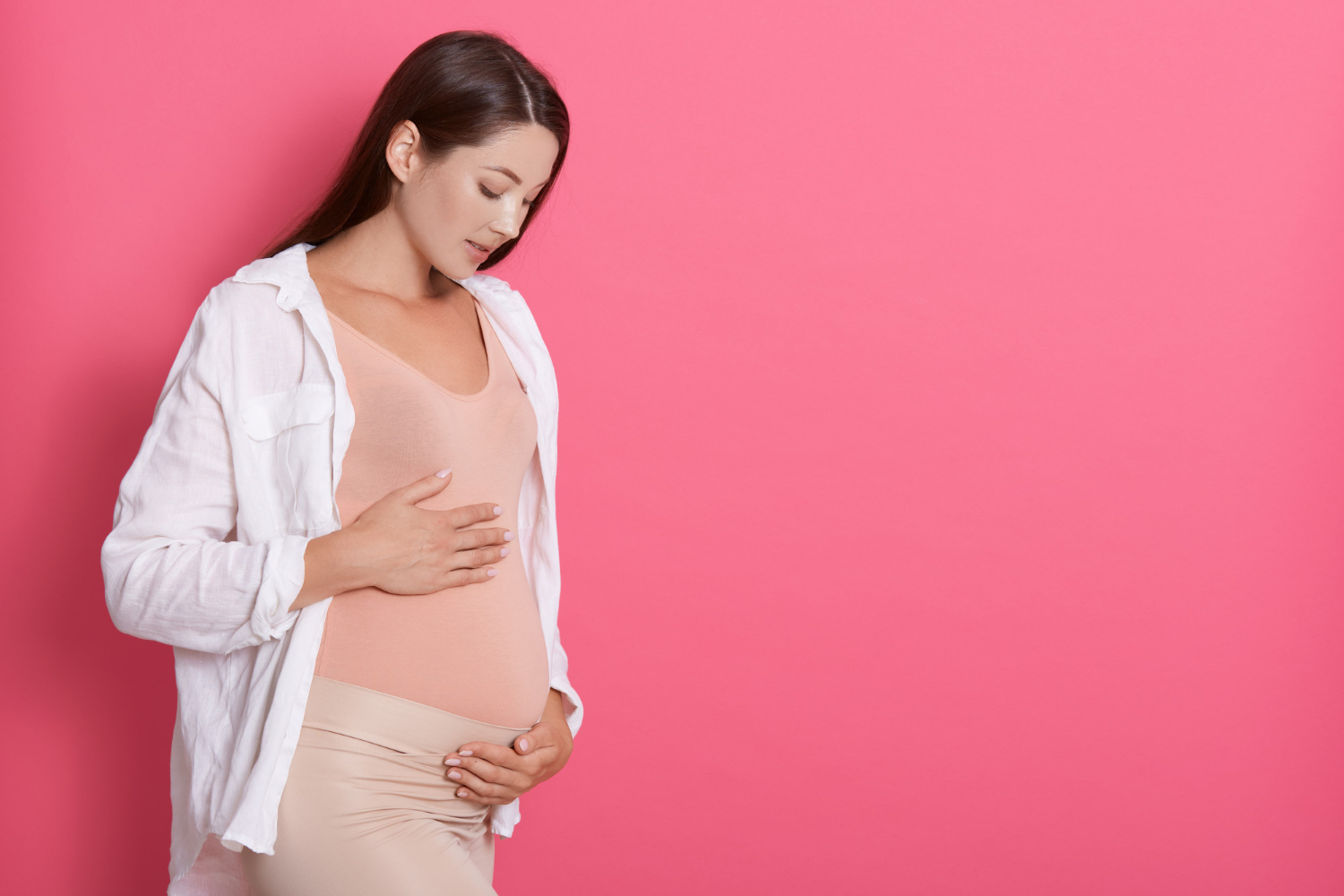Eine schwangere Frau, die auf ihren Babybauch schaut | Quelle: Freepik