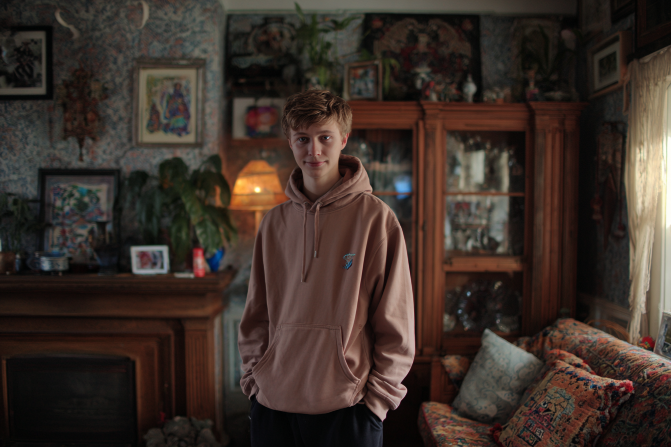 Ein Teenager-Junge steht in einem Wohnzimmer | Quelle: Midjourney