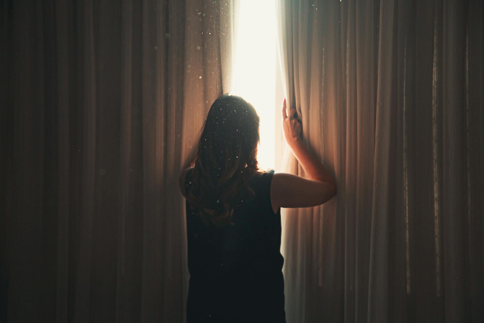 Eine Frau, die aus einem Fenster schaut | Quelle: Pexels