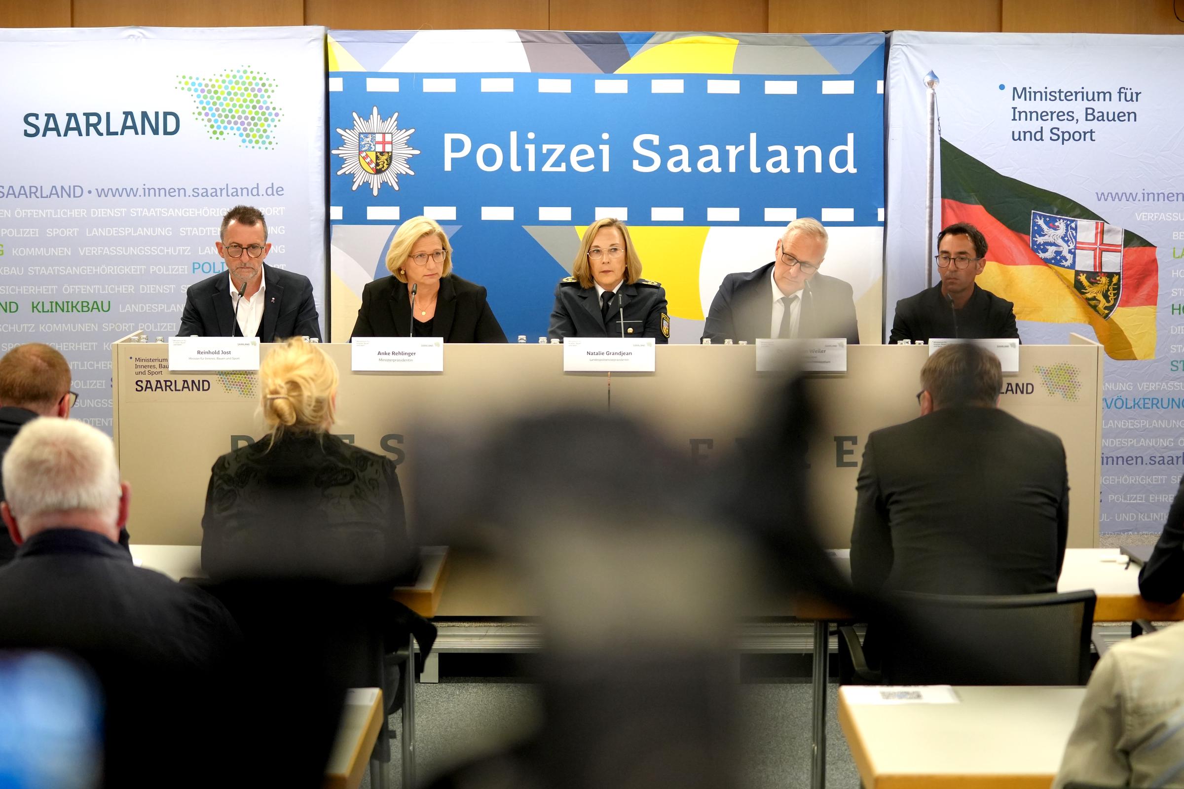 22. August 2025, Saarland, Völklingen: Reinhold Jost, Innenminister des Saarlandes, Anke Rehlinger (SPD), Ministerpräsidentin des Saarlandes, Natalie Grandjean, stellvertretende Polizeipräsidentin des Saarlandes, Thorsten Weiler, Polizeipräsident des Saarlandes, und Oberstaatsanwalt Christian Nassiry sprechen auf einer Pressekonferenz. | Quelle: Getty Images