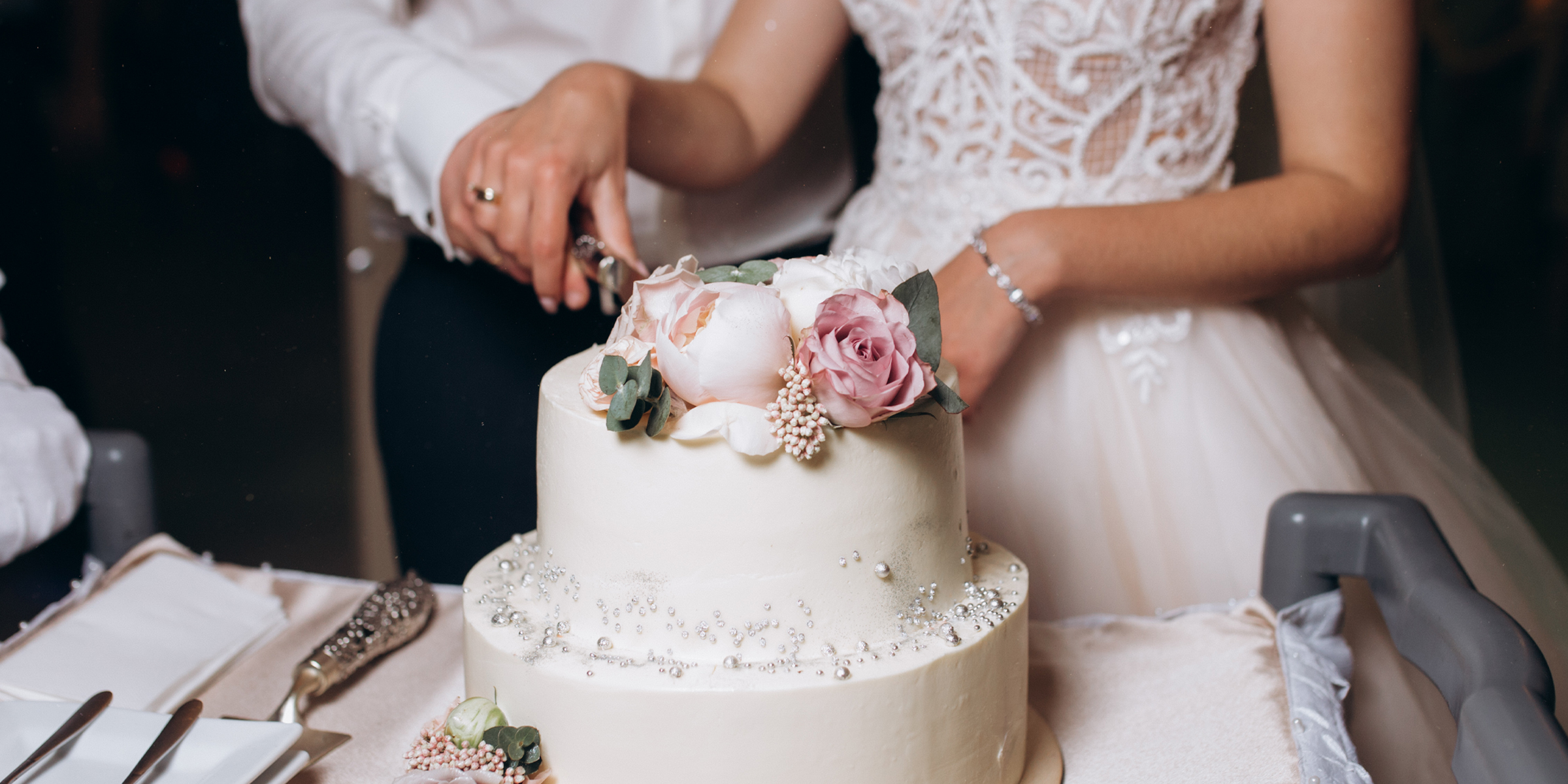 Braut und Bräutigam schneiden eine Torte an | Quelle: Freepik