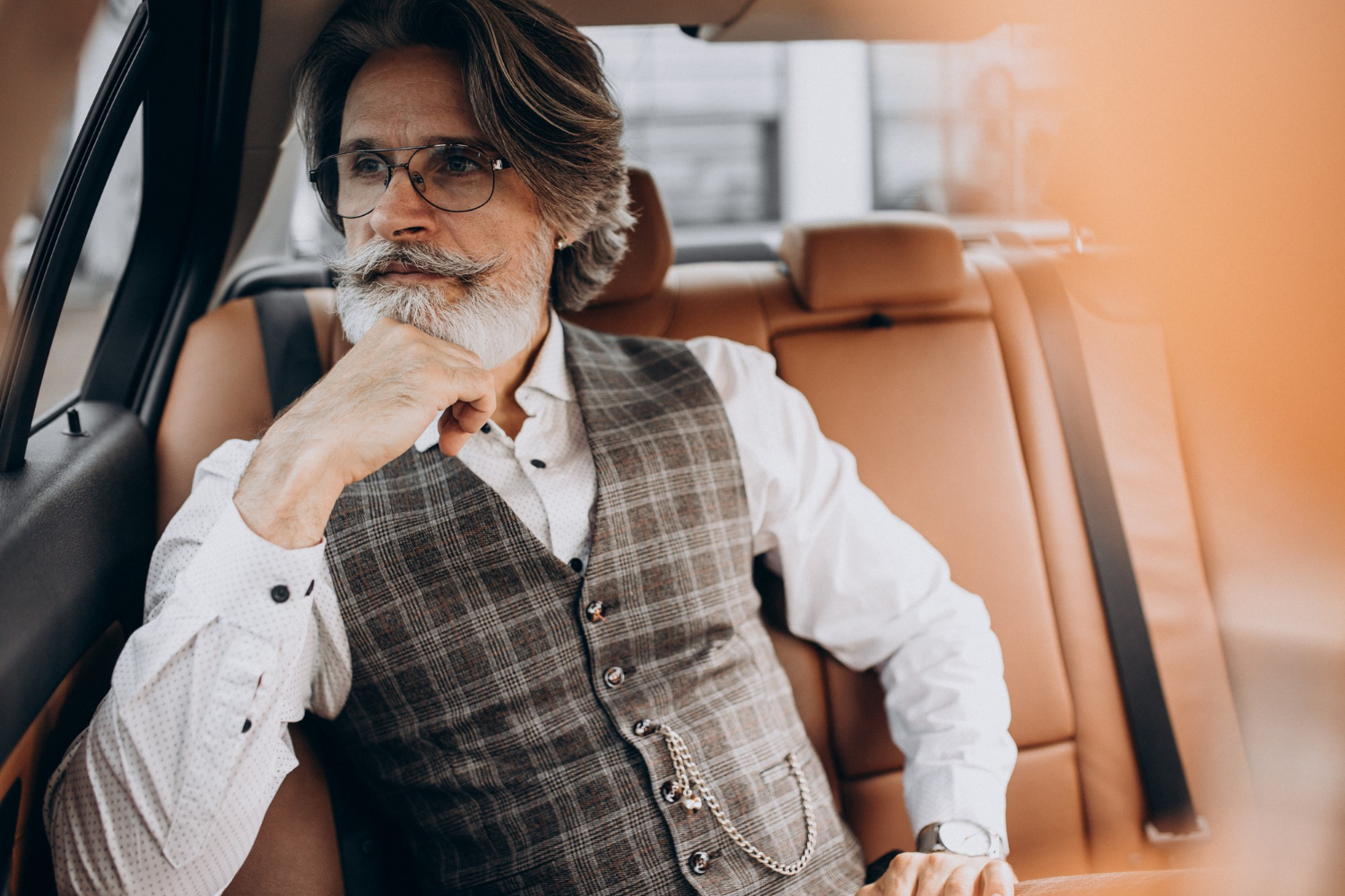Ein eleganter älterer Mann sitzt in seinem Auto | Quelle: Freepik