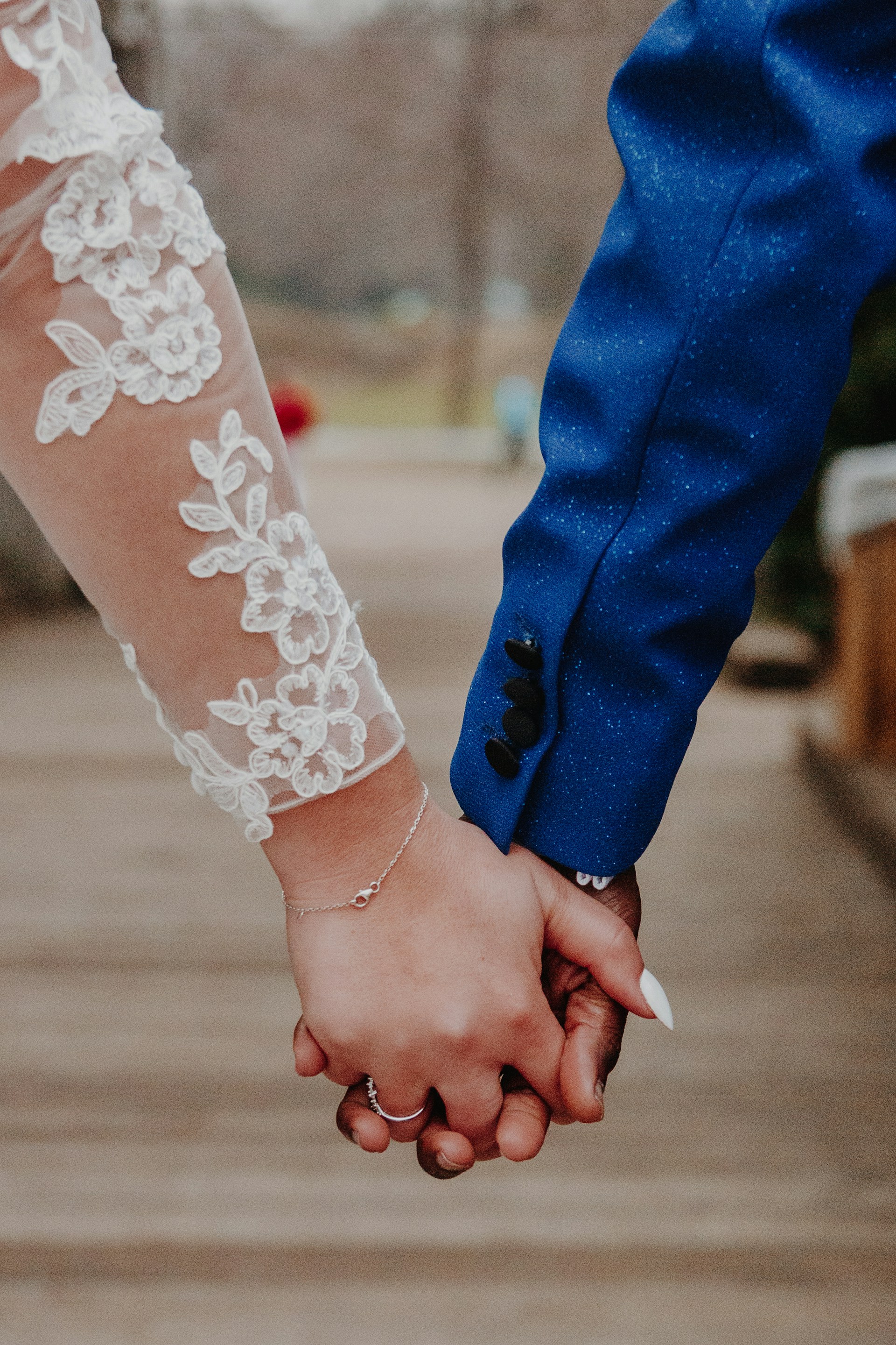 Eine Braut und ein Bräutigam halten sich an den Händen | Quelle: Unsplash