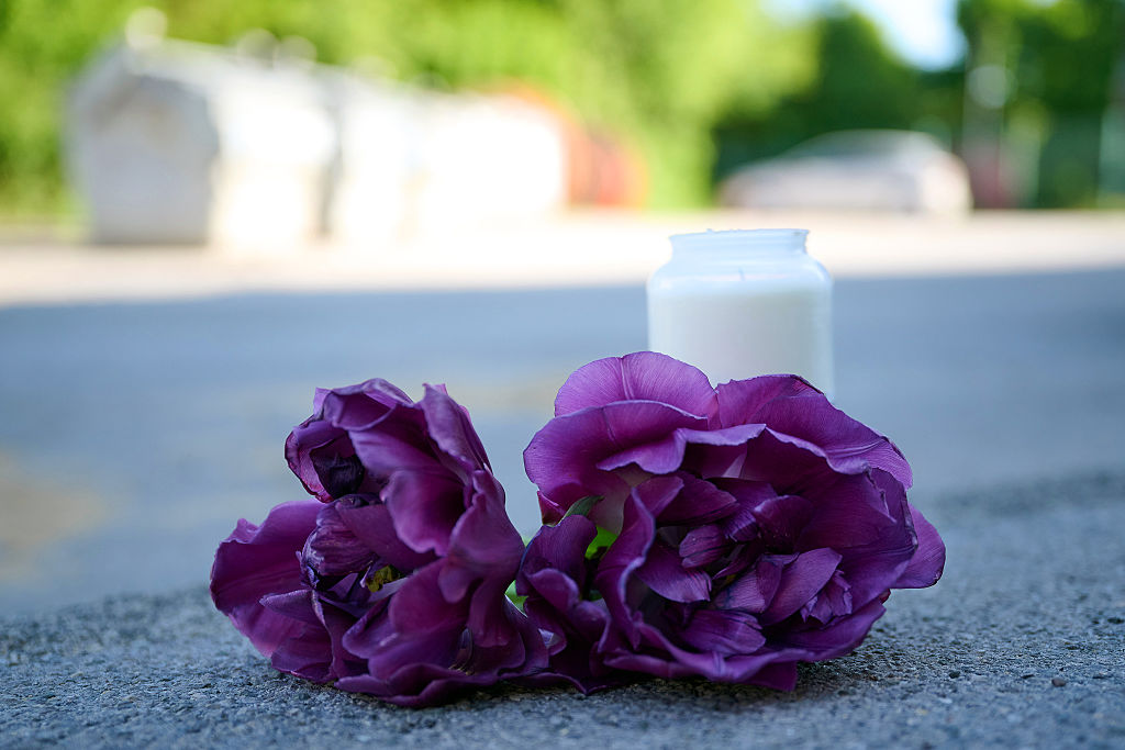 10. Mai 2025, Nordrhein-Westfalen, Menden: Blumen und eine Kerze liegen auf einem Kiesplatz vor dem Eingang zu einem Spielplatz. Ein 17-Jähriger soll einen 14-Jährigen auf einem Spielplatz im Sauerland erstochen haben. | Quelle: Getty Images