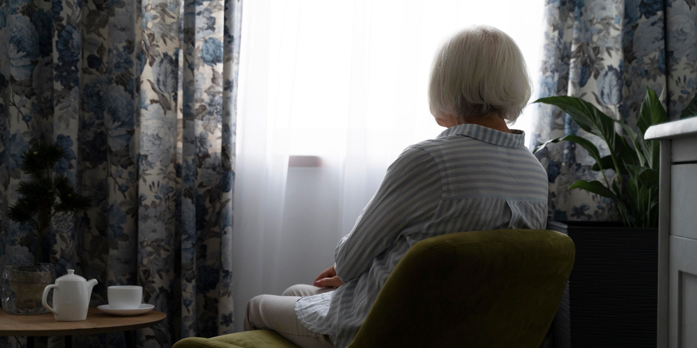 Eine ältere Frau sitzt am Fenster | Quelle: Freepik