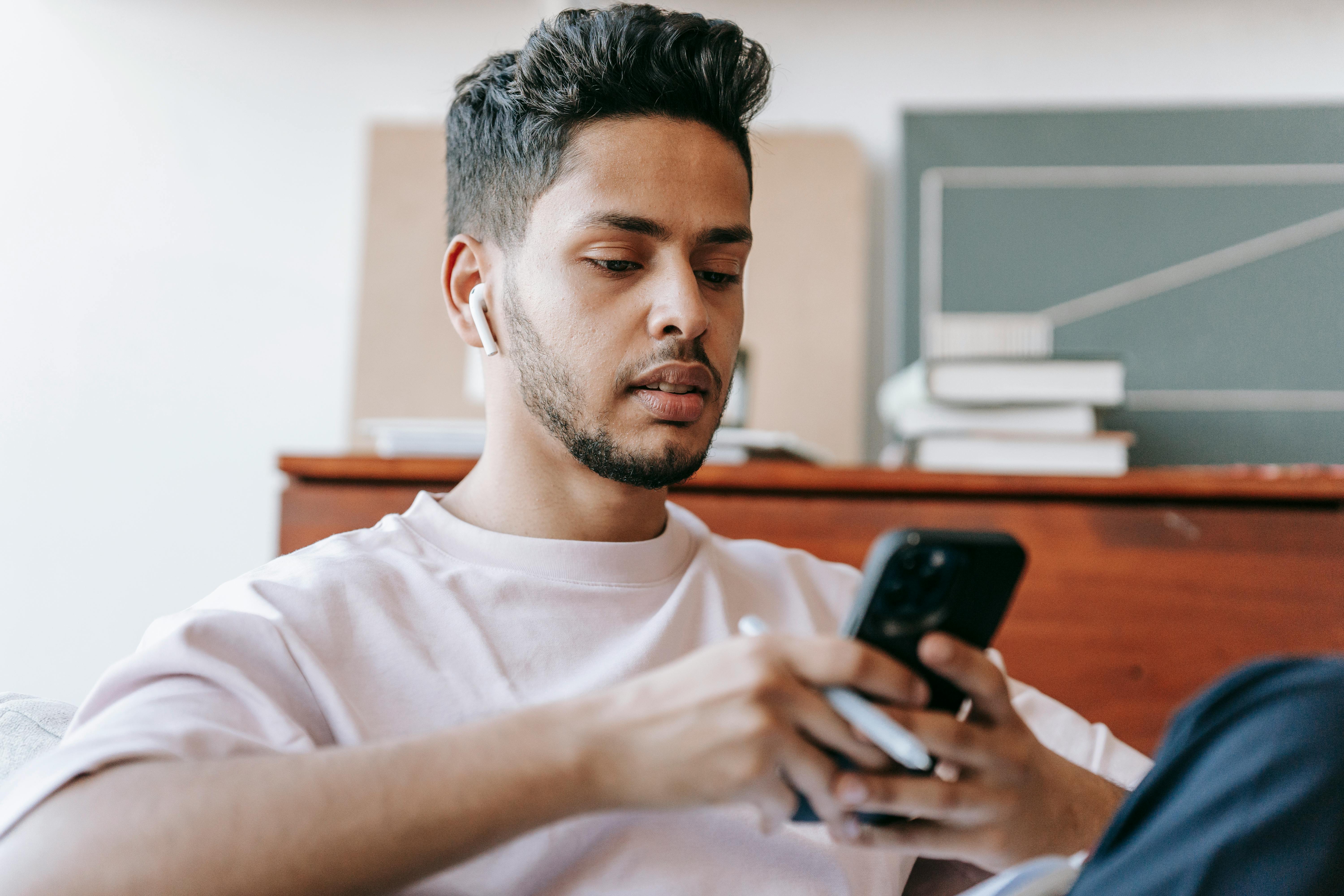 Ein junger Mann benutzt sein Smartphone | Quelle: Pexels