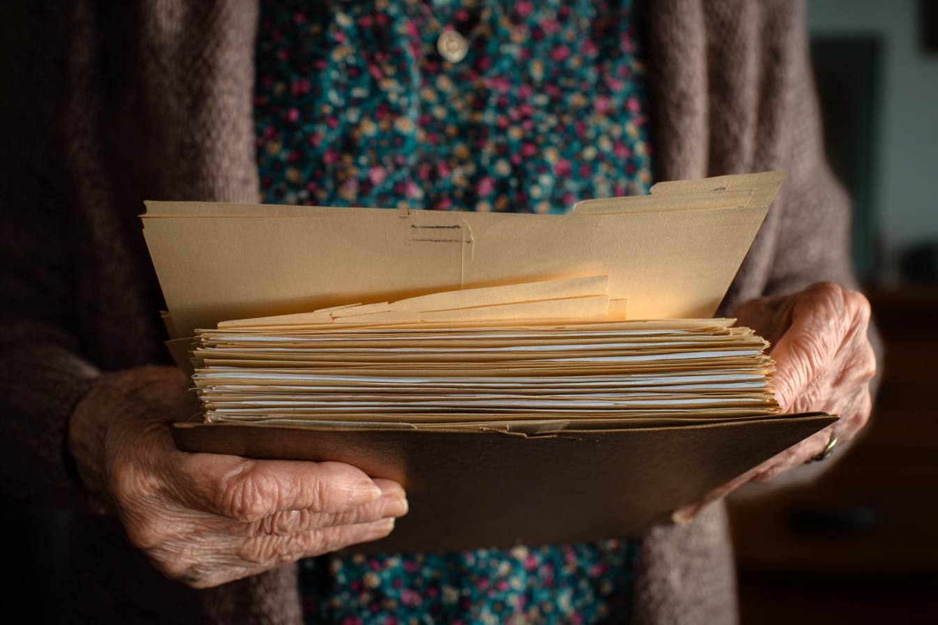 Eine ältere Frau, die einen Ordner hält | Quelle: Midjourney