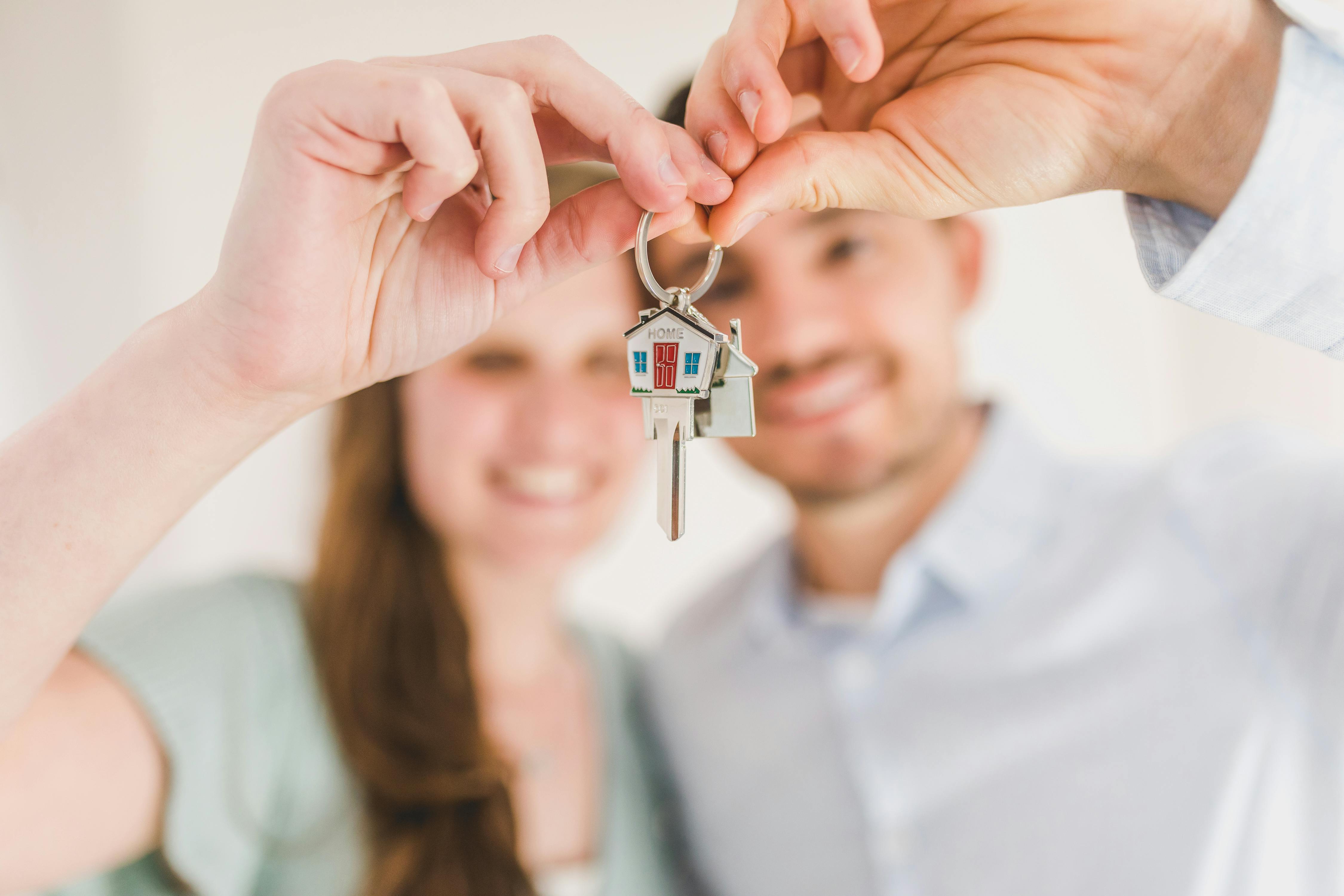 Ein Paar mit einem Schlüssel zu seinem neuen Haus | Quelle: Pexels