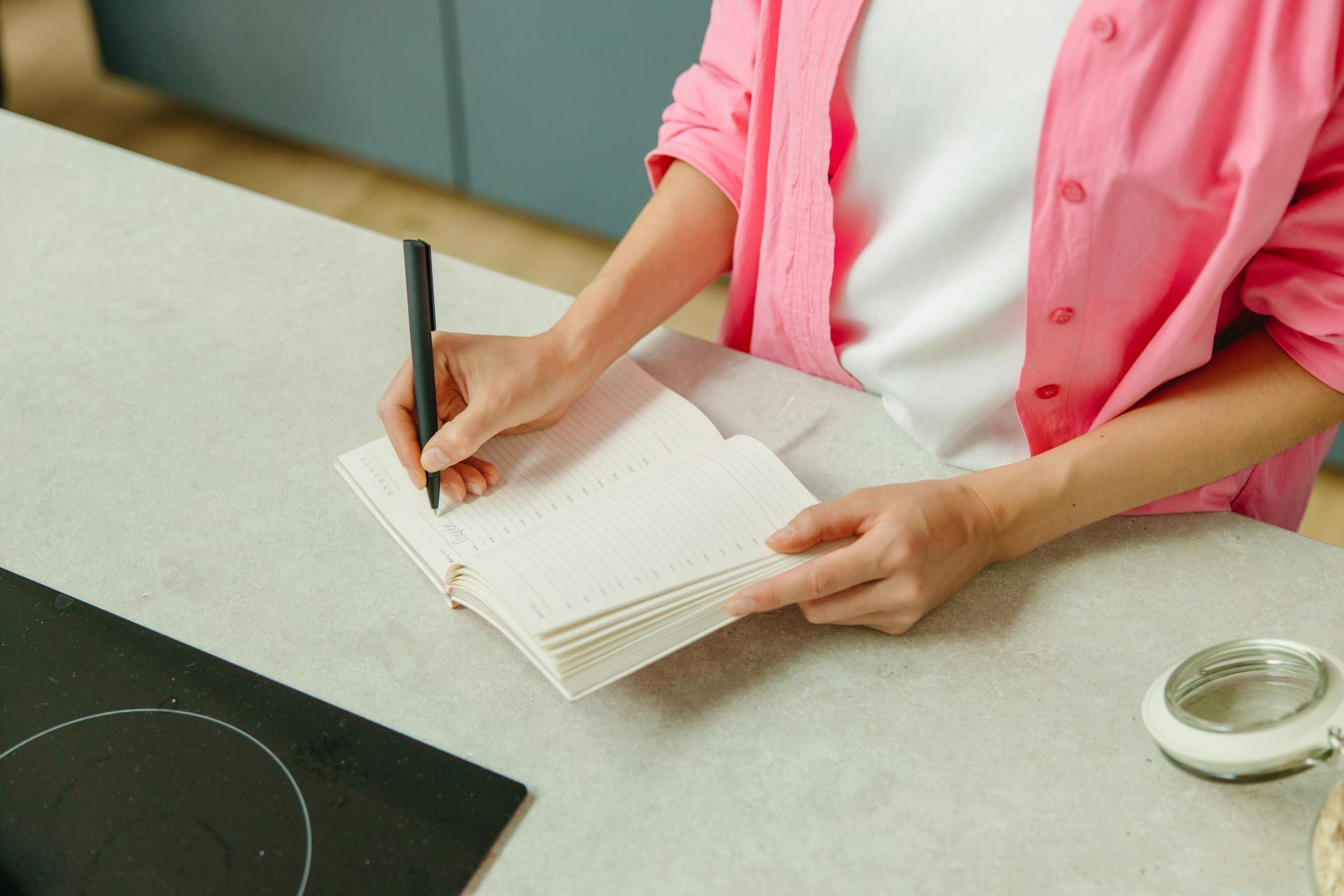 Eine Nahaufnahme einer Frau, die in ein Notizbuch schreibt | Quelle: Pexels