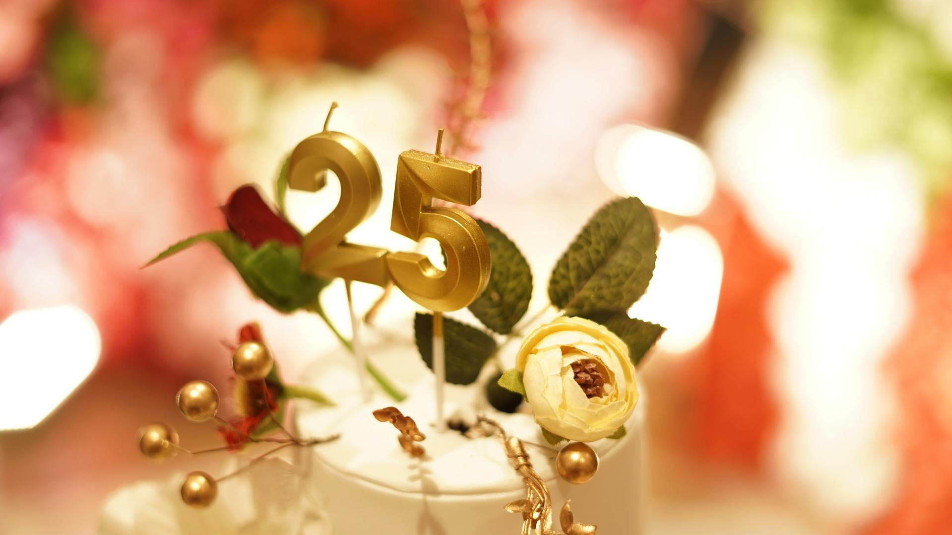 Ein goldener Tortentopper zum 25-jährigen Jubiläum mit Blumen | Quelle: Pexels