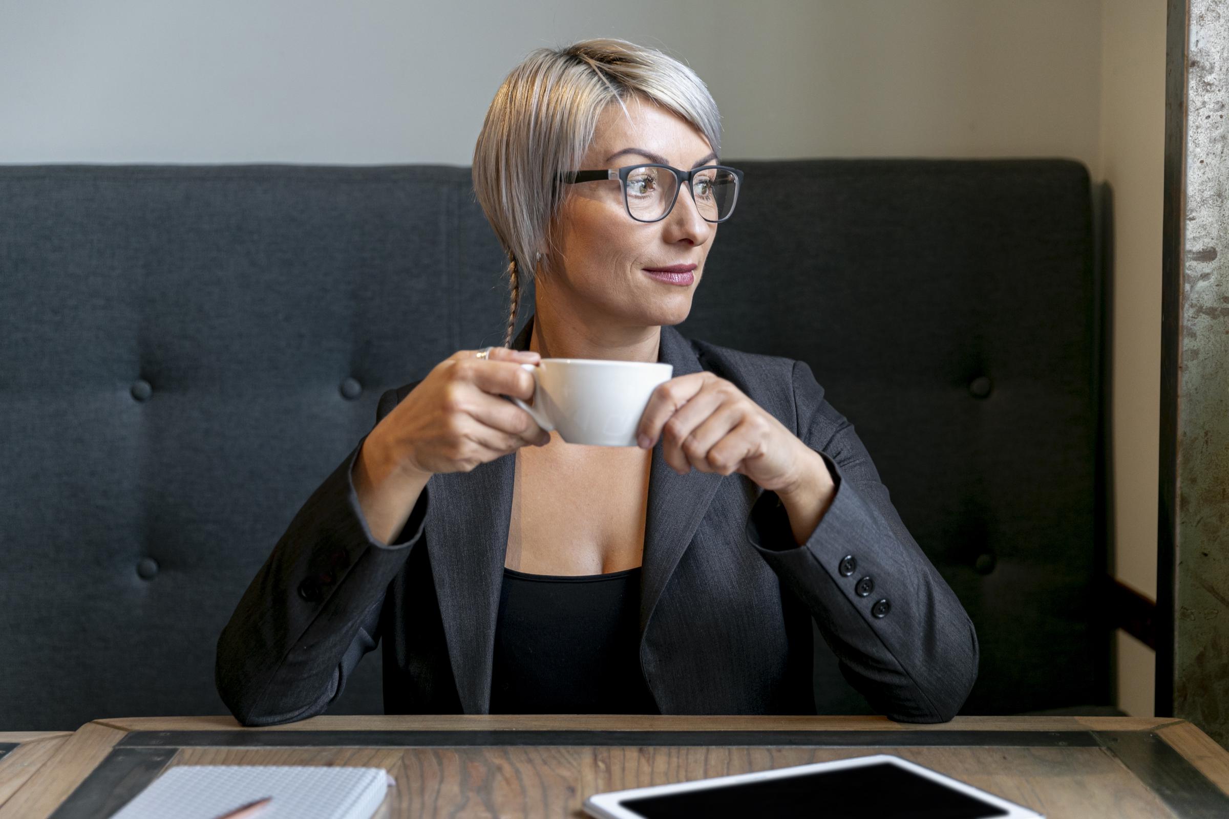 Eine fröhliche Frau mit einer Tasse Kaffee in der Hand | Quelle: Freepik