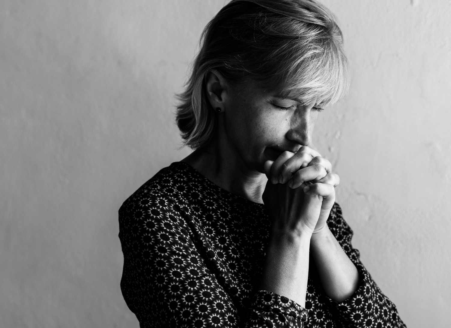 Graustufenaufnahme einer entschuldigenden Frau | Quelle: Freepik