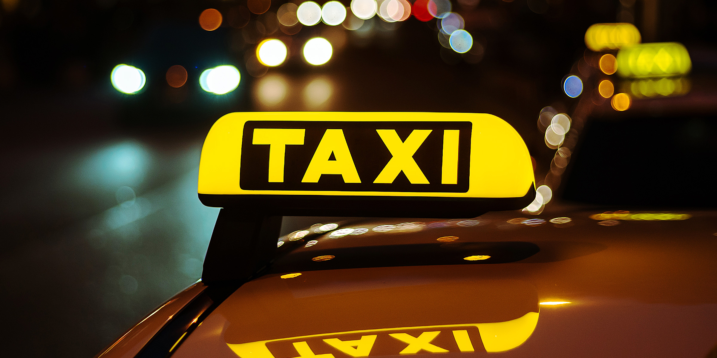 Ein gelbes und schwarzes Schild eines Taxis auf einem Auto | Quelle: Freepik