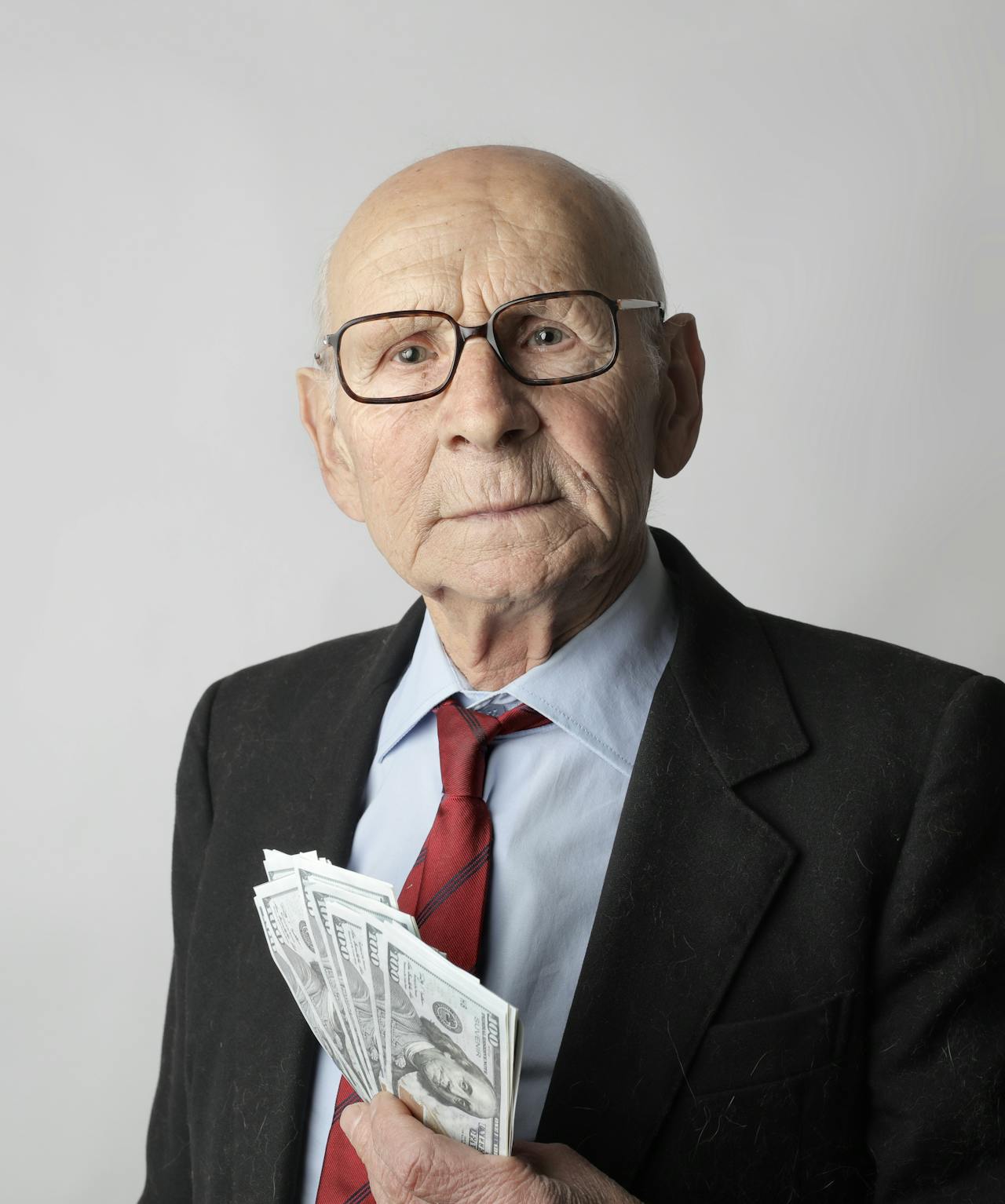 Ein reicher älterer Mann mit Geld in der Hand | Quelle: Pexels