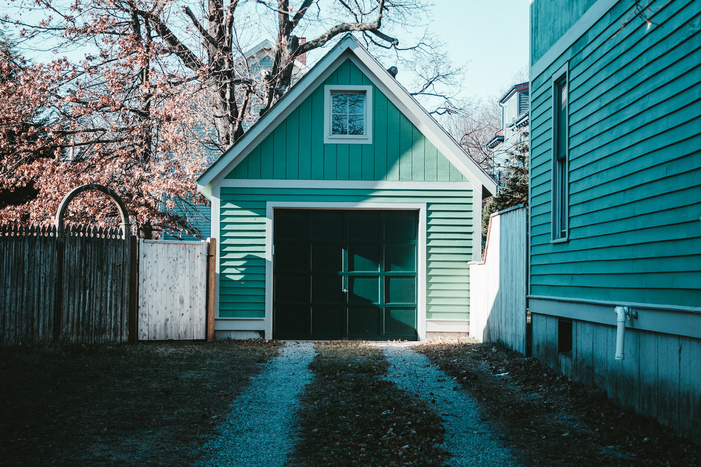 Ein tealfarbenes Haus und eine Garage in einem Hinterhof | Quelle: Unsplash
