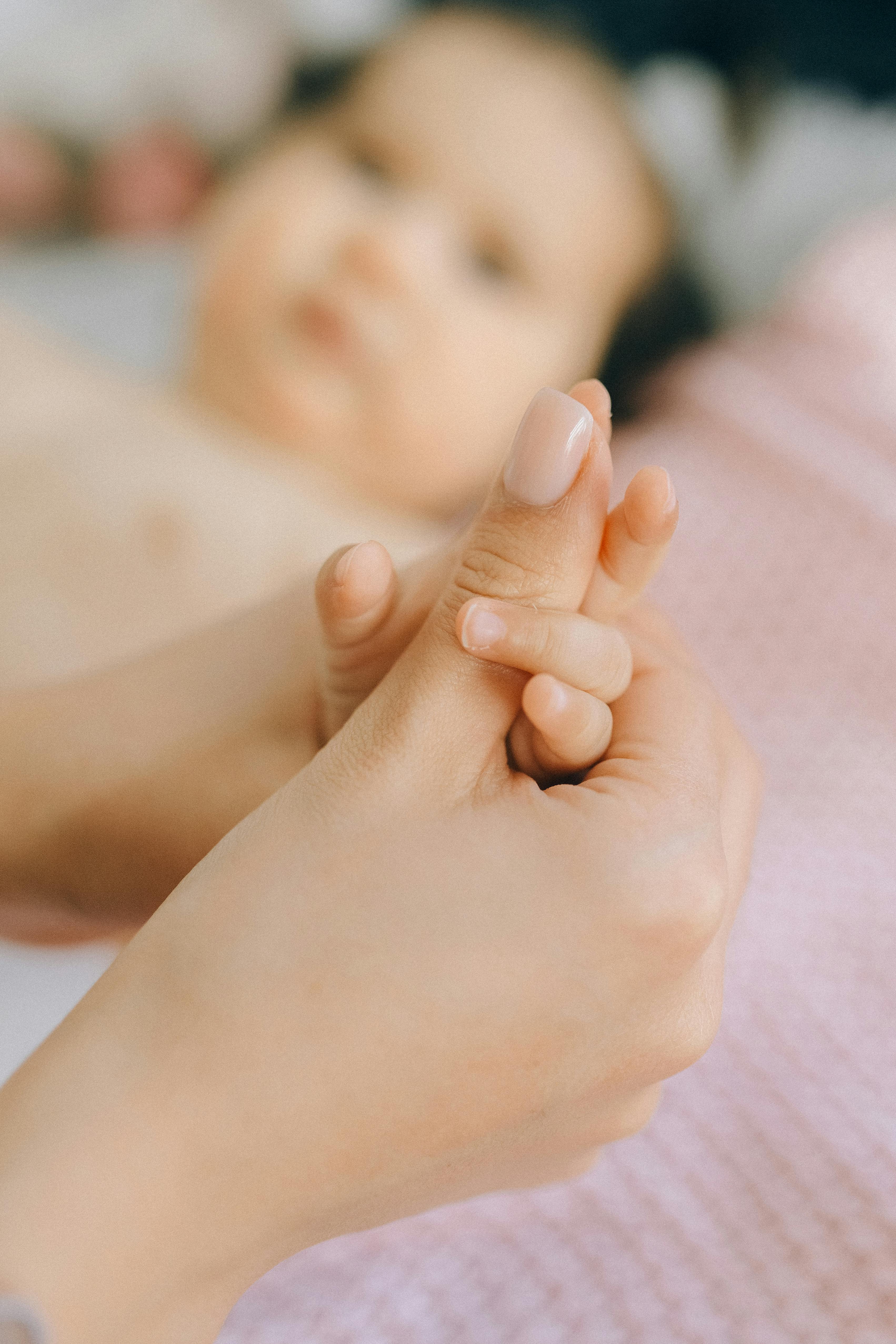 Ein neugeborenes Baby, das die Hand seiner Mutter hält | Quelle: Pexels