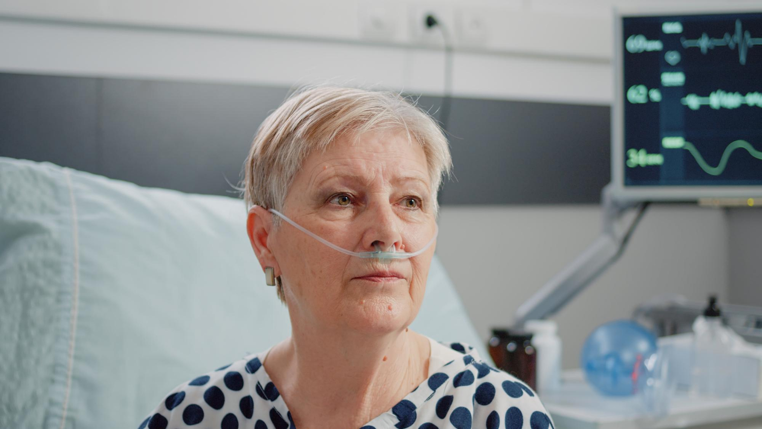 Eine alte Frau, die in einer Krankenstation sitzt und starrt | Quelle: Freepik