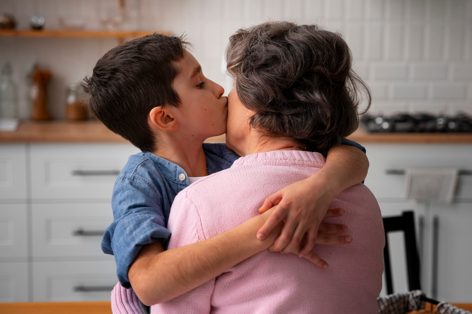 Ein kleiner Junge küsst seine Großmutter auf die Wange | Quelle: Freepik