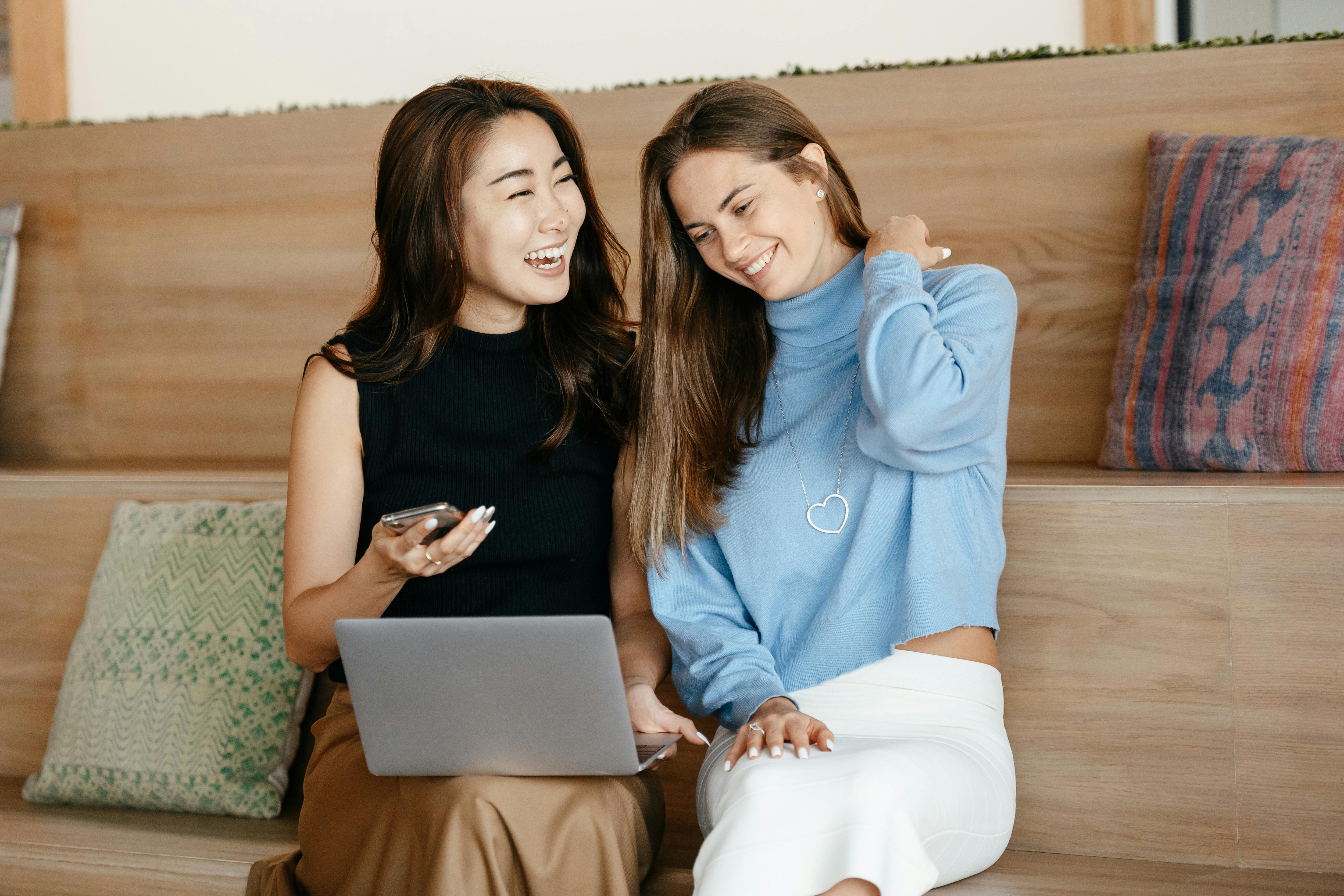 Zwei Frauen lachen, während sie auf einen Laptop schauen | Quelle: Pexels