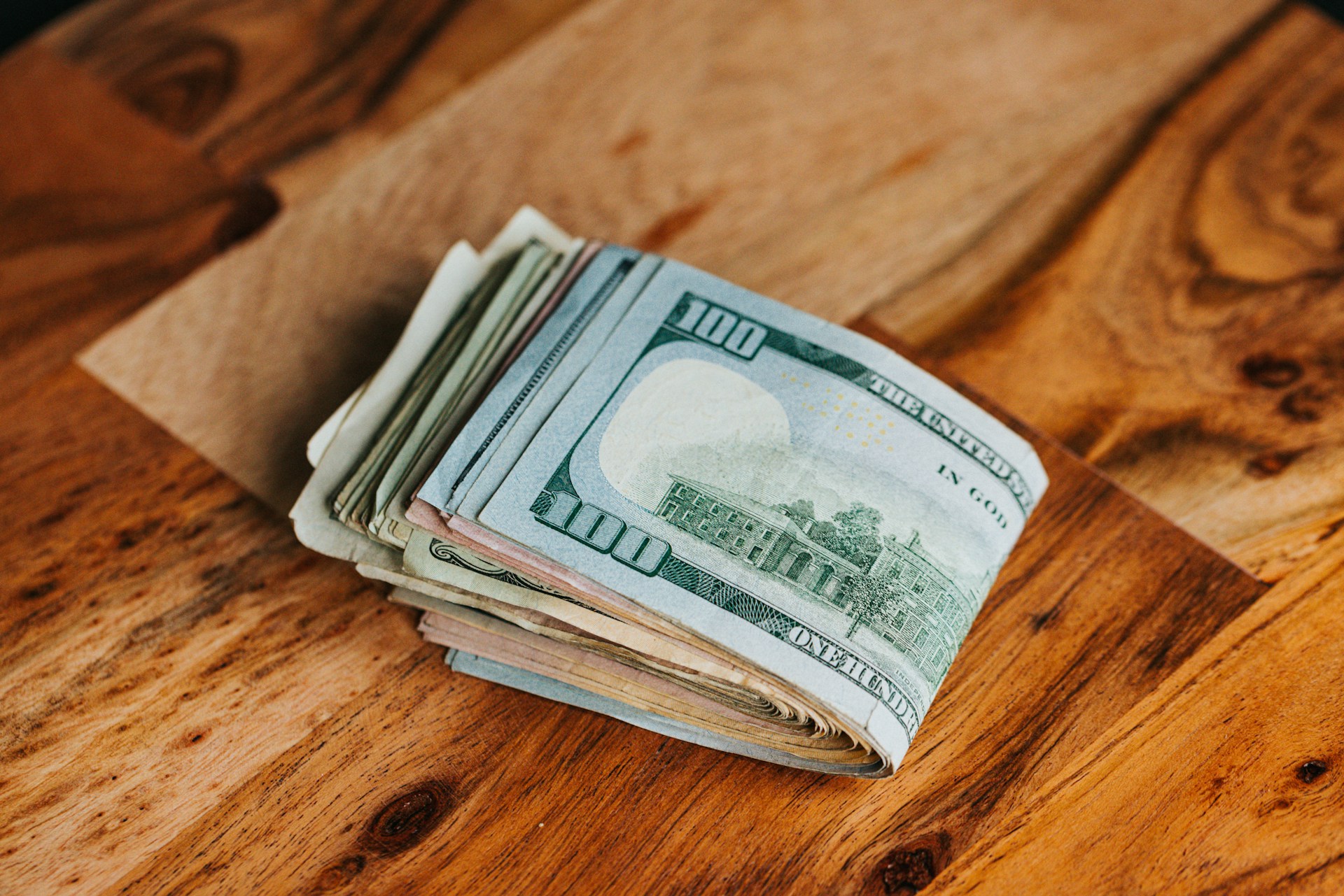 Dollarscheine auf einer Holzoberfläche | Quelle: Unsplash