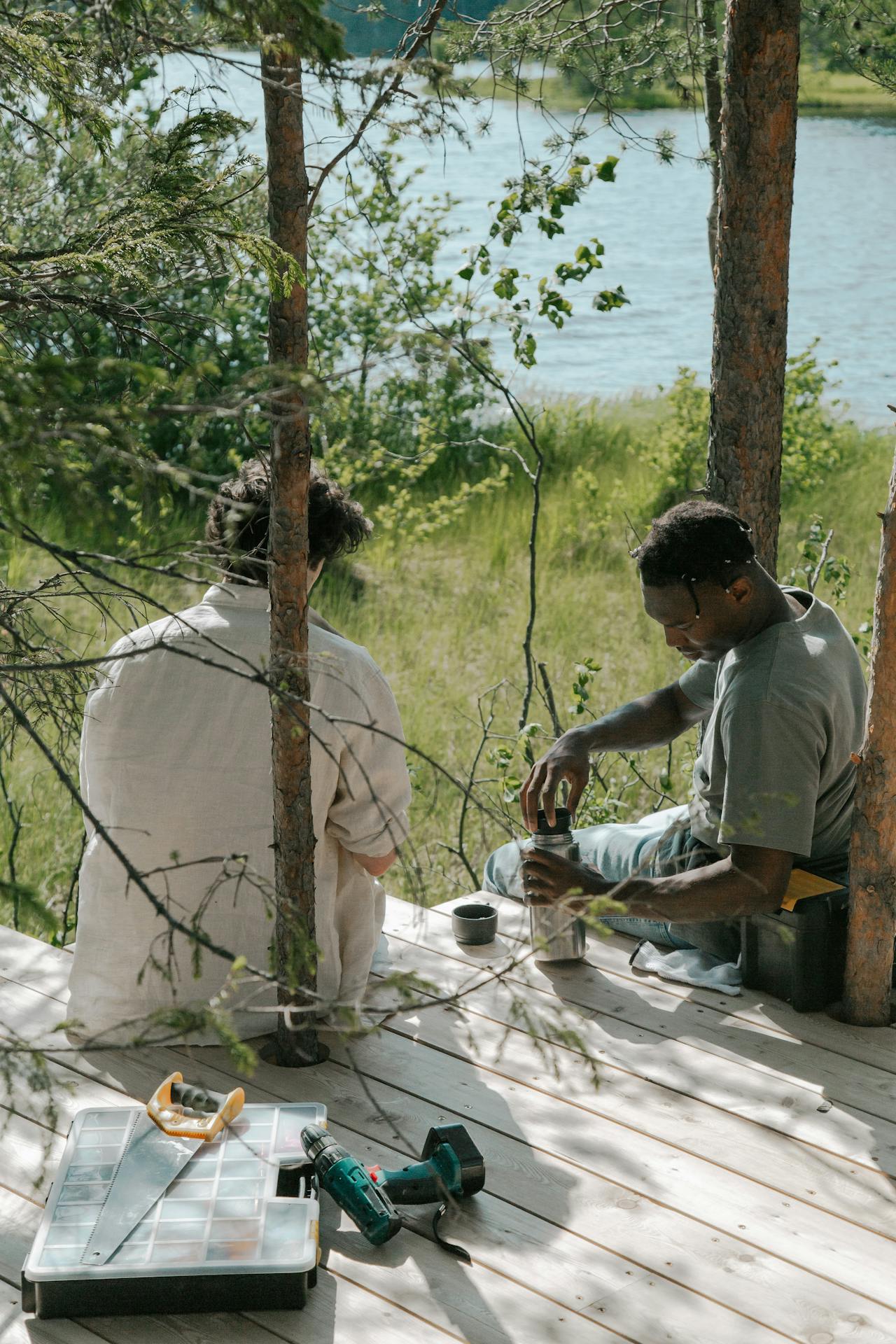 Zwei Männer sitzen auf Holzbrettern | Quelle: Pexels