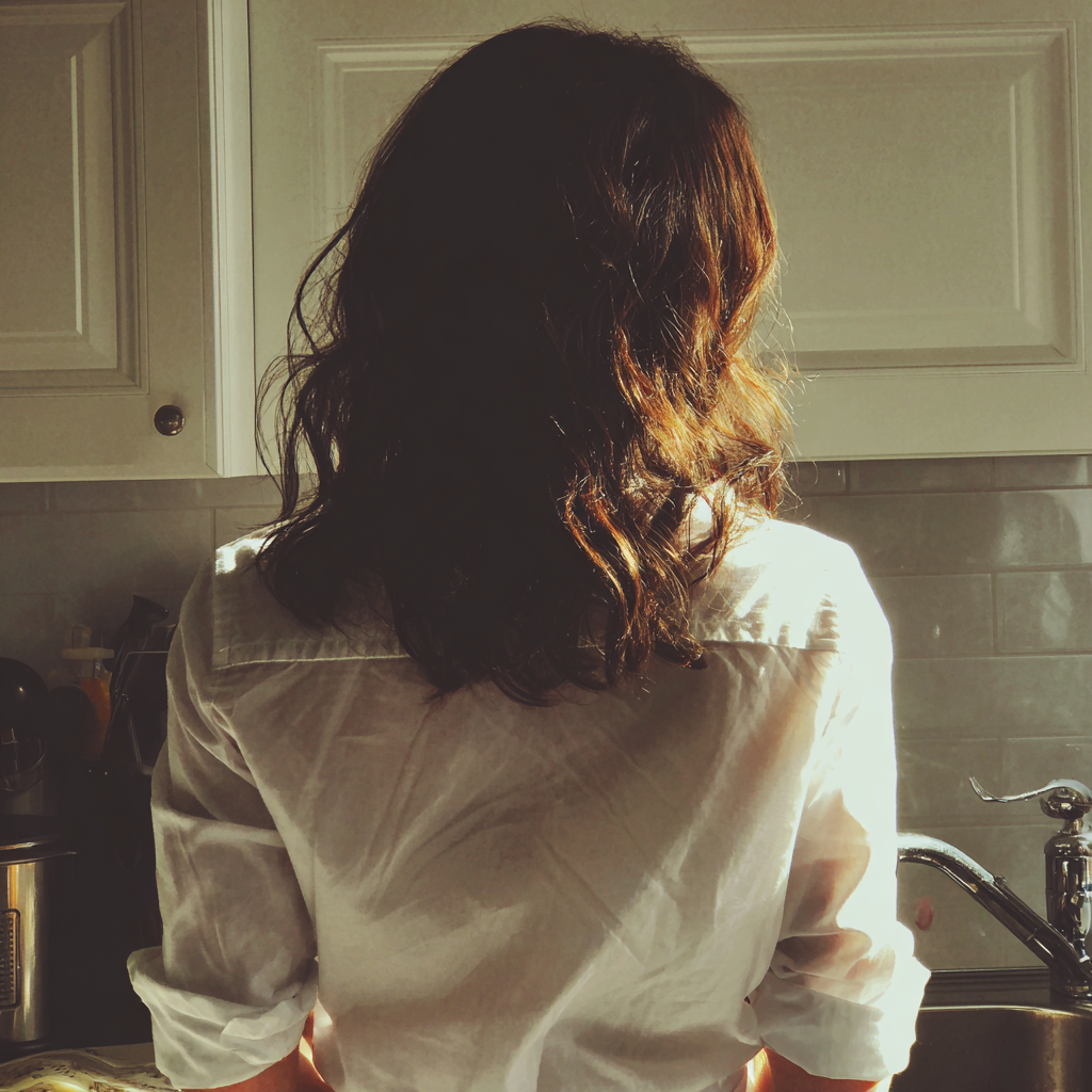 Eine Frau, die an einer Spüle steht | Quelle: Midjourney