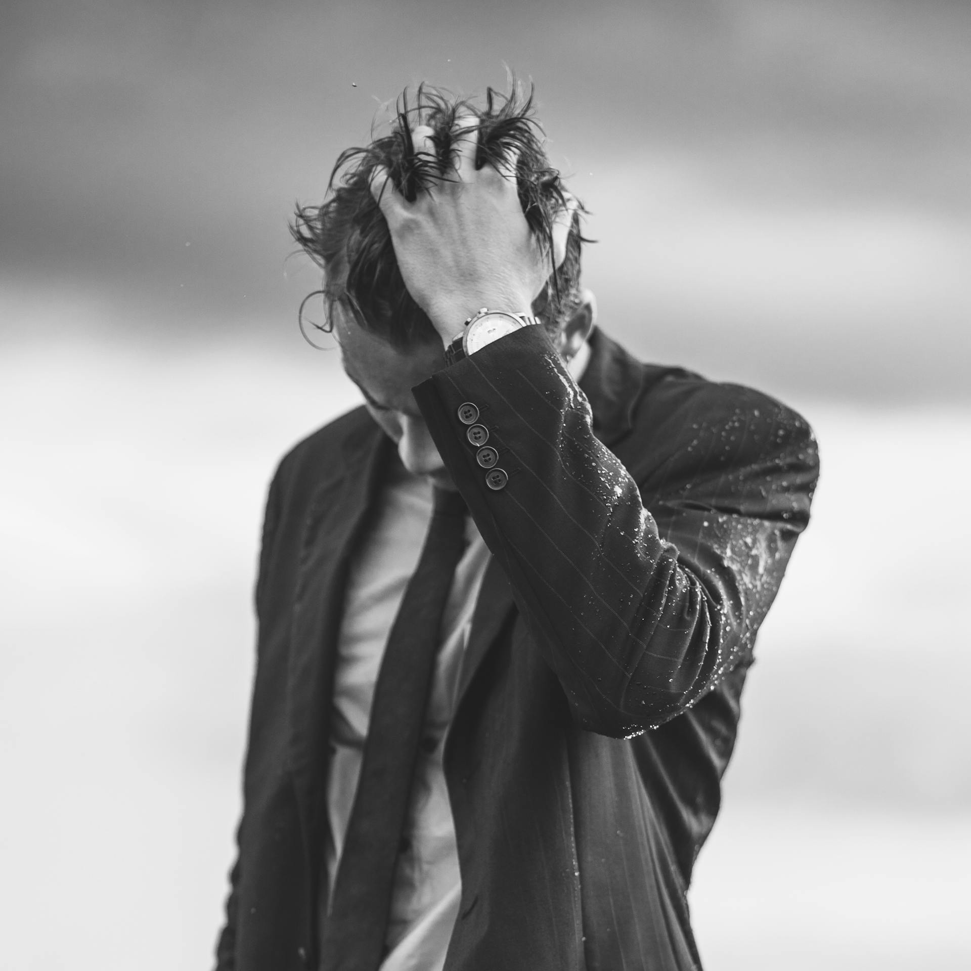 Ein Mann im Anzug mit den Händen in den Haaren | Quelle: Pexels