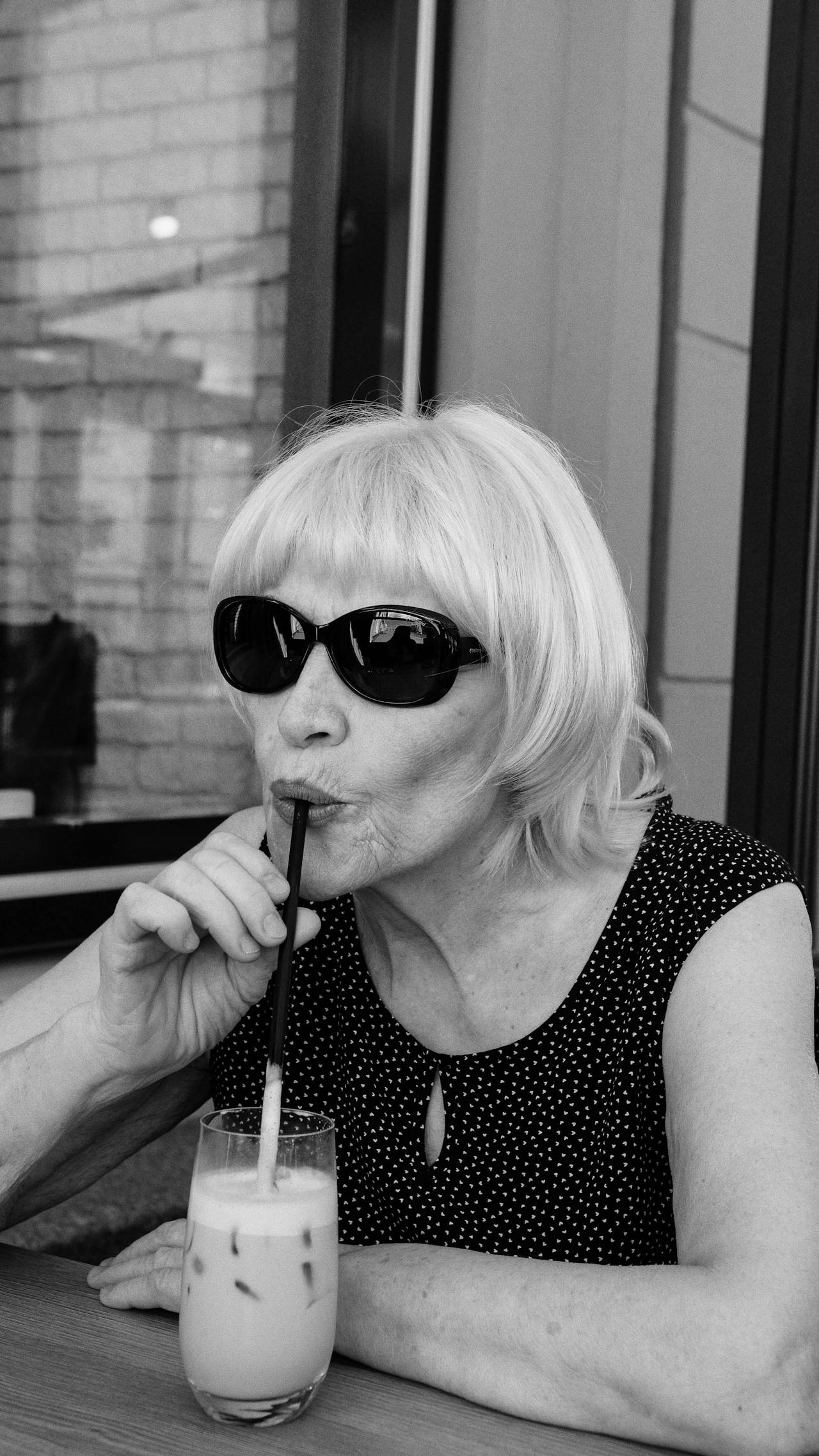 Graustufenaufnahme einer älteren Frau, die ein Glas Getränk trinkt | Quelle: Pexels