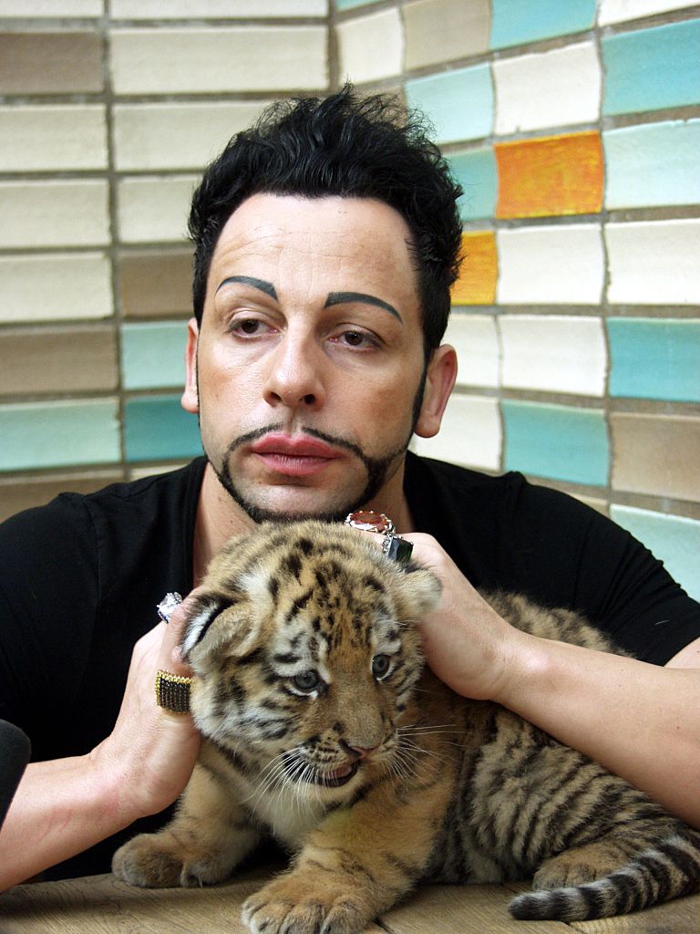Harald Glööckler, Modeschöpfer, mit einem jungen Tiger im Tierpark Berlin-Friedrichsfelde | Quelle: Getty Images