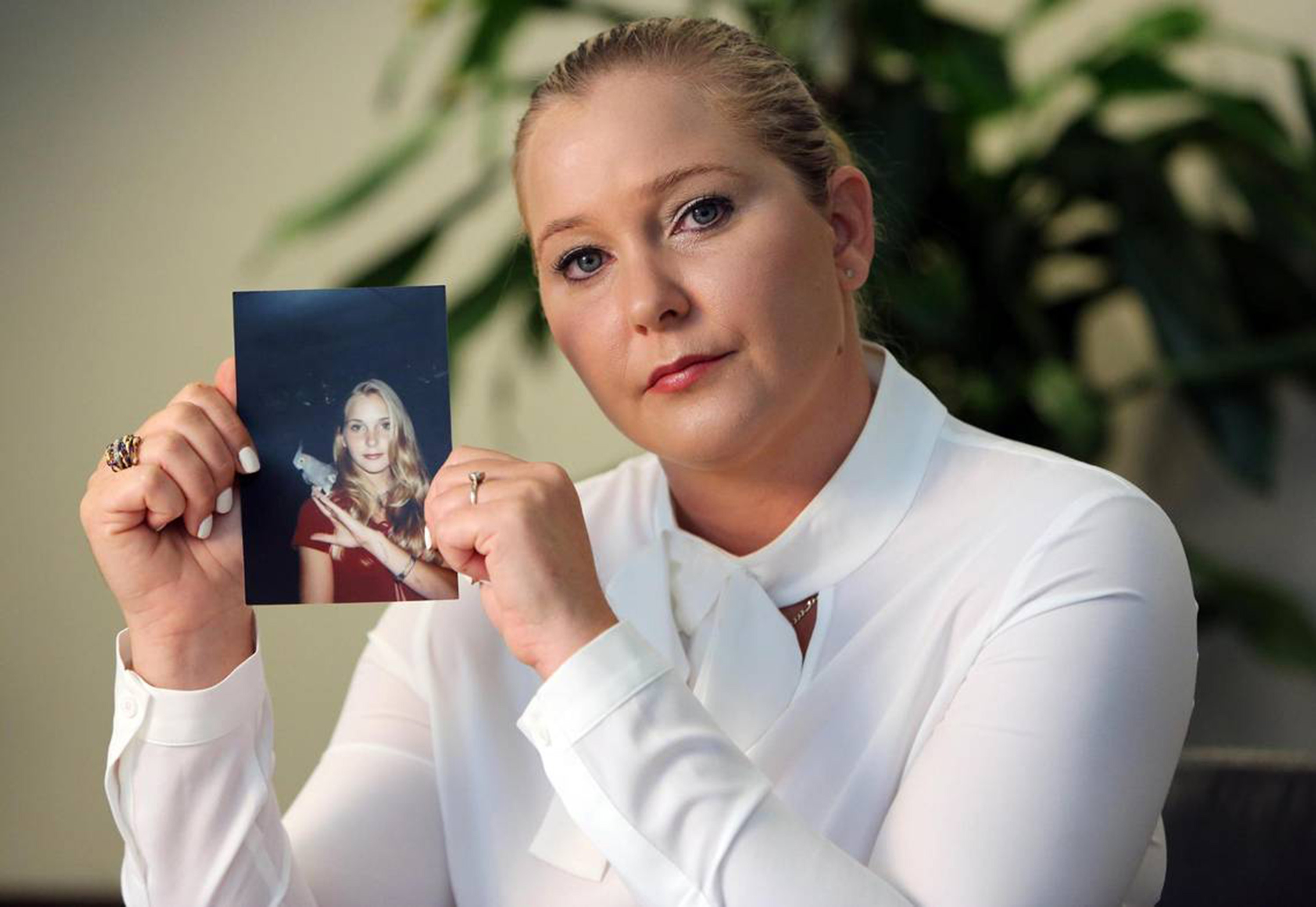 Virginia Giuffre mit einem Foto von sich selbst als Teenager, auf dem sie sagt, dass sie unter anderem von Jeffrey Epstein, Ghislaine Maxwell und Prinz Andrew missbraucht wurde, vom 1. März 2023 | Quelle: Getty Images