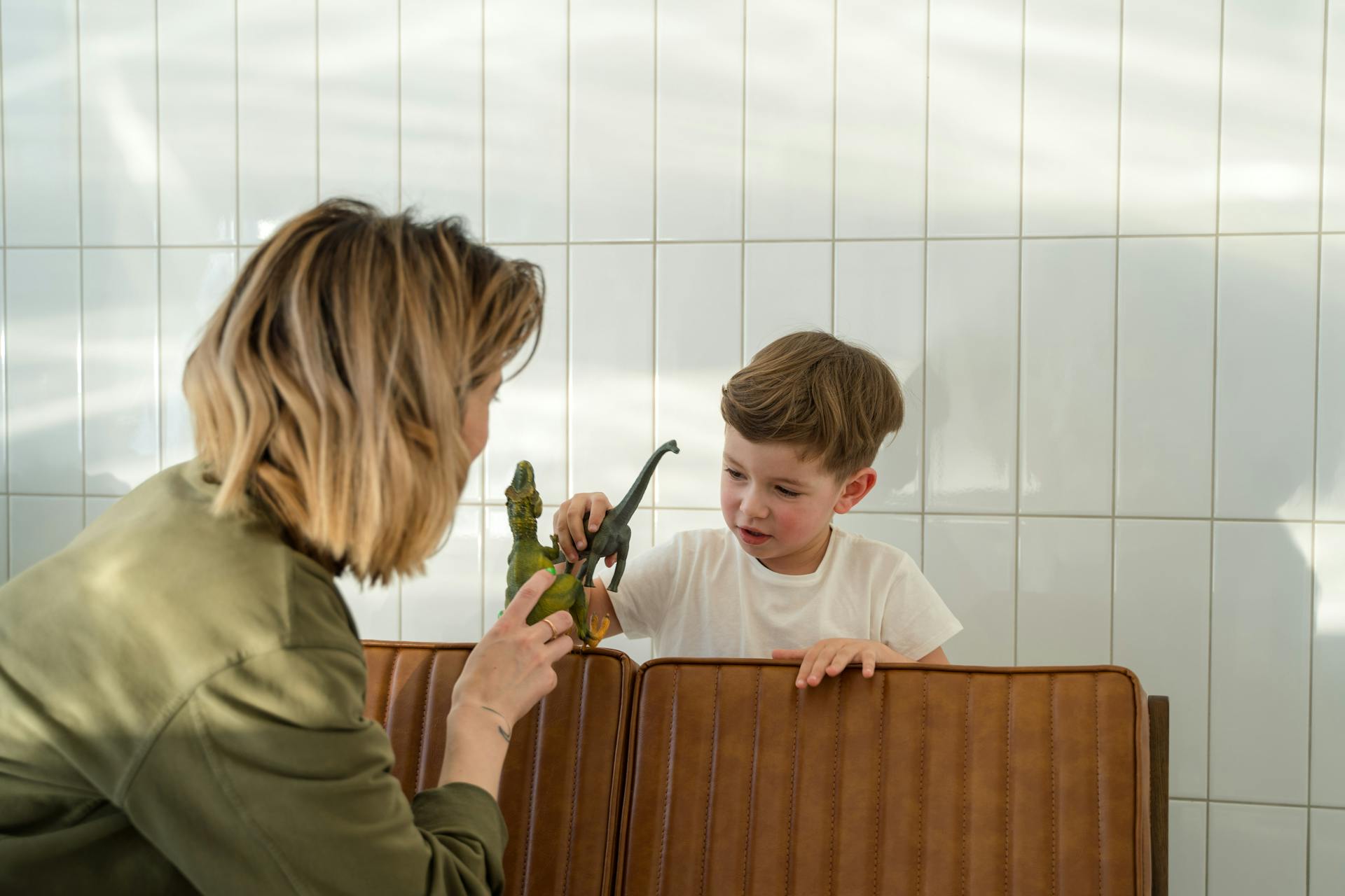 Eine Frau spielt mit ihrem Sohn auf einer Bank | Quelle: Pexels