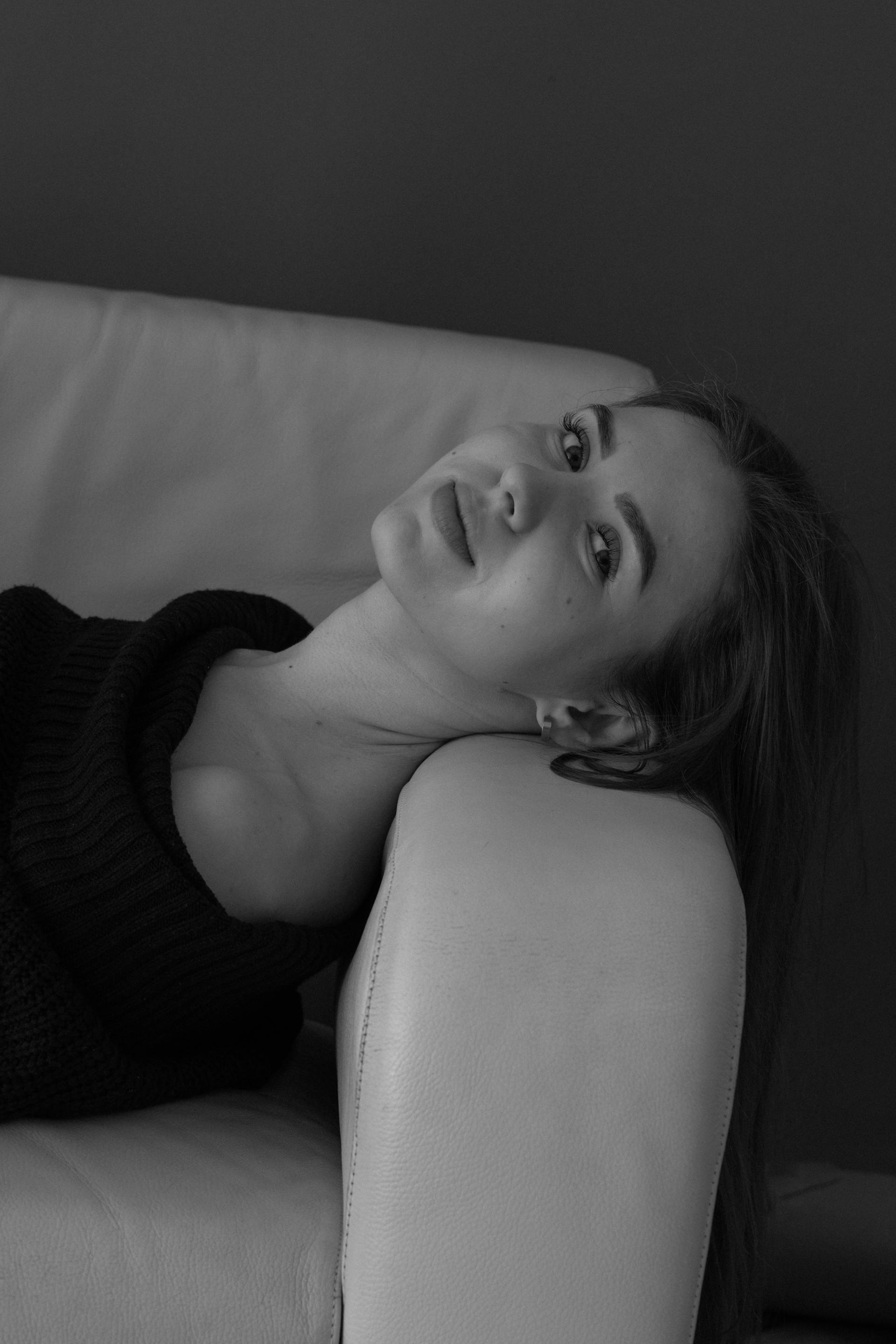 Ein Graustufenfoto von einer Frau, die auf einem Sofa liegt | Quelle: Pexels