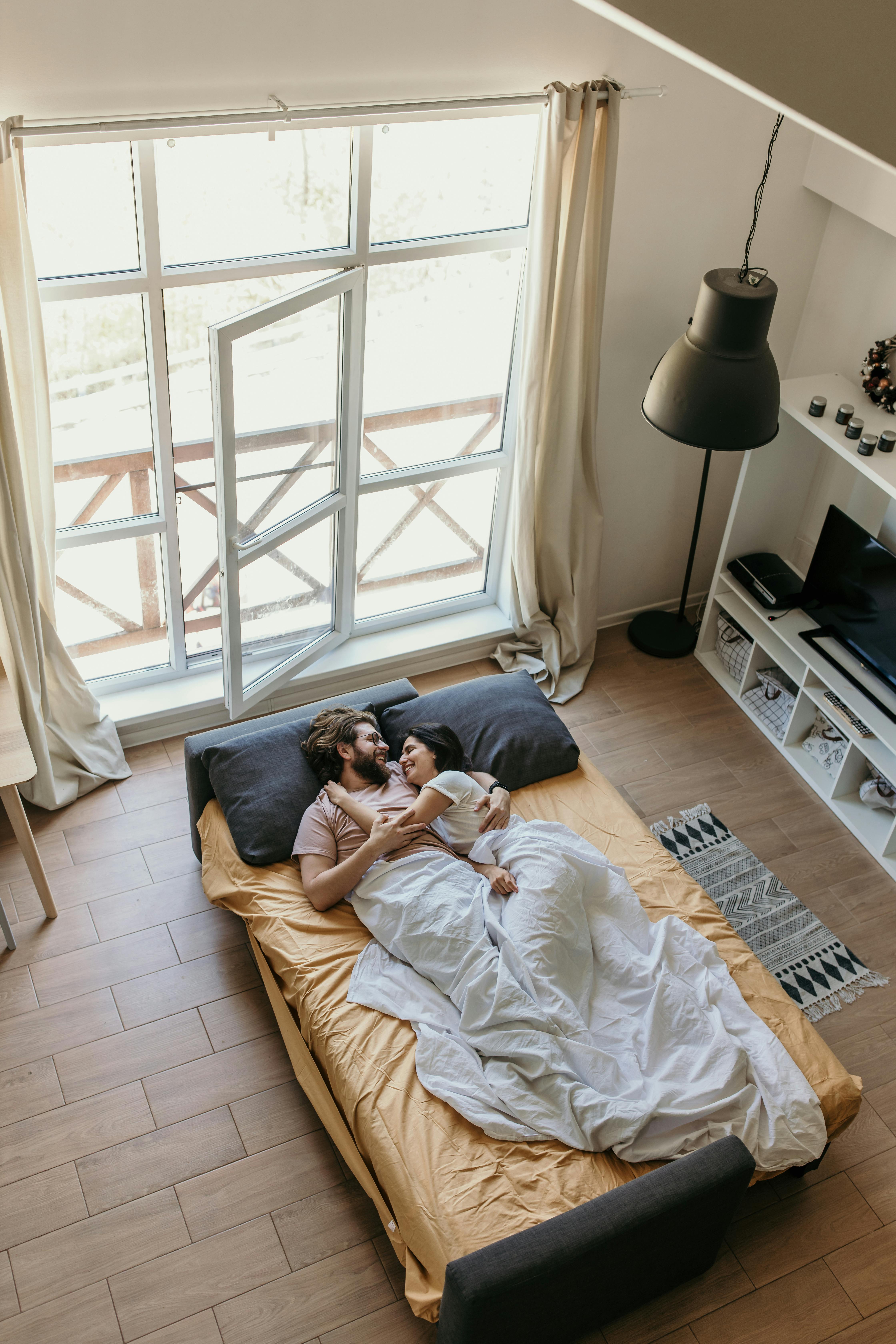 Ein glückliches Paar im Bett | Quelle: Pexels