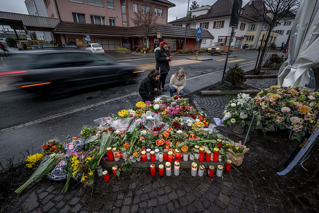 Am 11. März 2026, einen Tag nachdem sechs Leute bei einem Busbrand ums Leben gekommen sind, zeigen die Leute in Kerzers in der Westschweiz vor Kerzen und Blumen ihre Anteilnahme. | Quelle: Getty Images