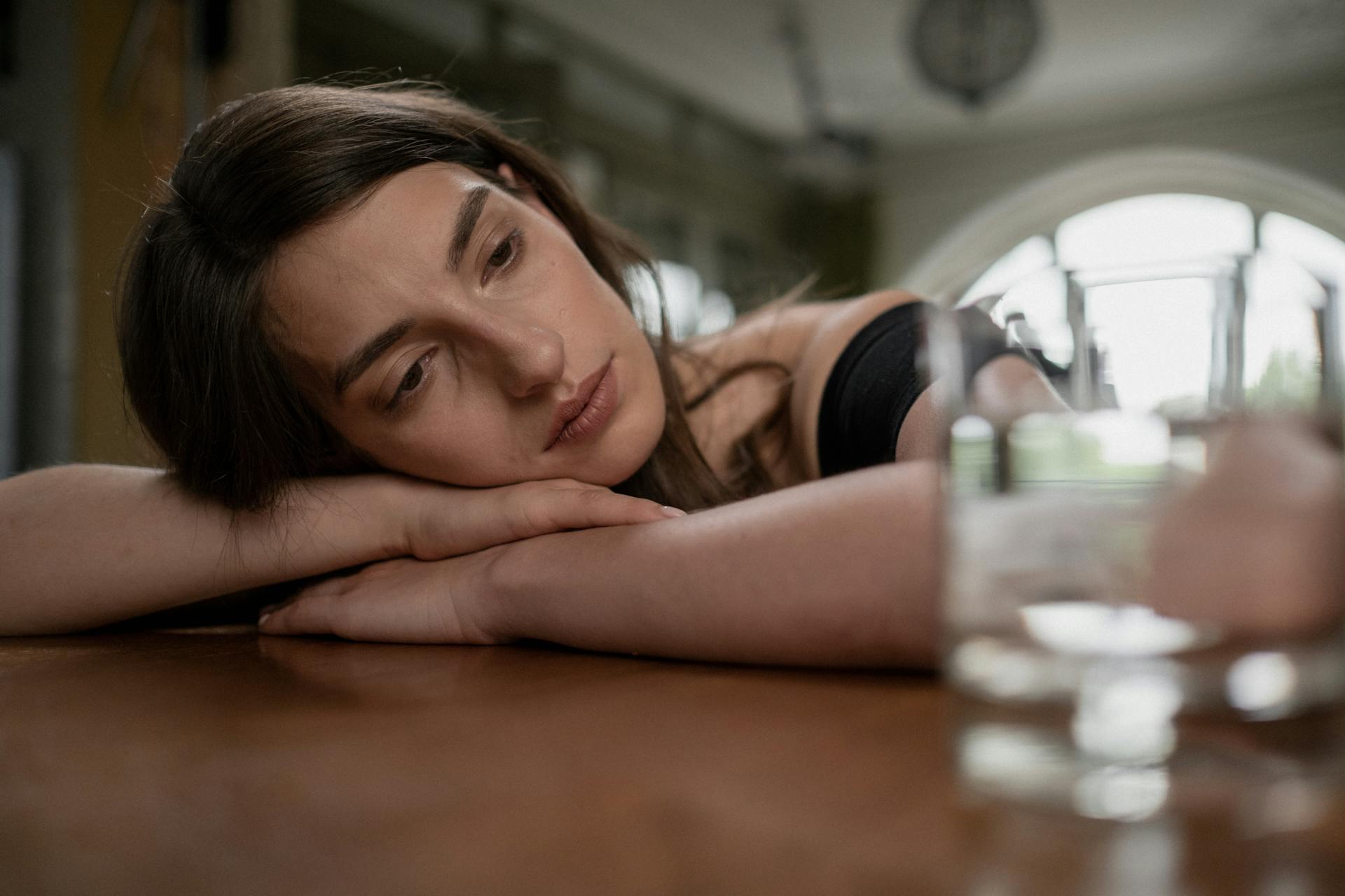 Eine besorgte Frau mit ihrem Kopf auf einem Tisch | Quelle: Pexels