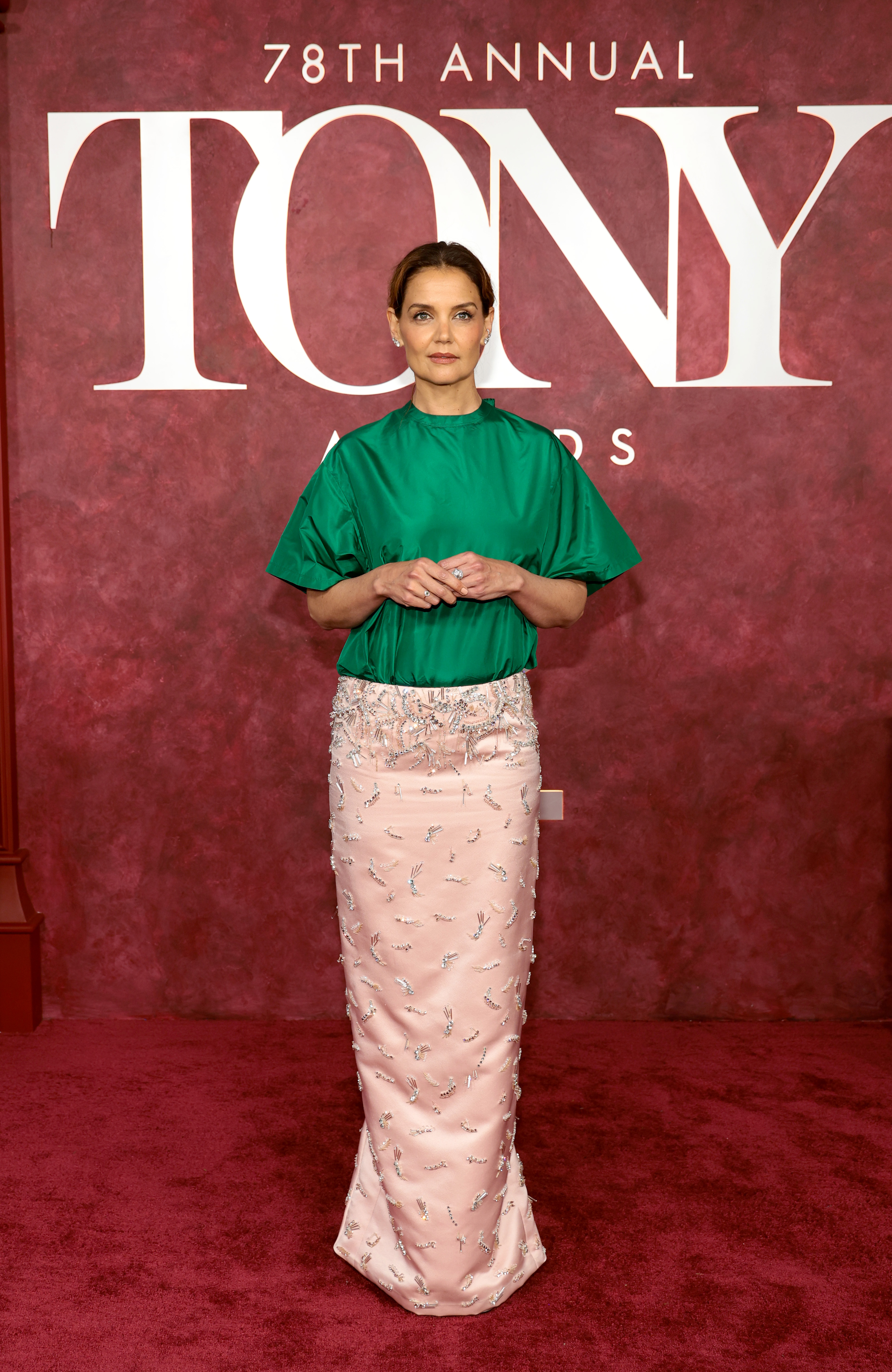Eingerahmt vom offiziellen Tony Awards-Schriftzug nimmt Katie Holmes eine breite Haltung ein und hält die Hände sanft umschlungen. Die Komposition von Kopf bis Fuß unterstreicht das unkonventionelle Gleichgewicht von Volumen, Glanz und verschnörkelten Details des Kleides.