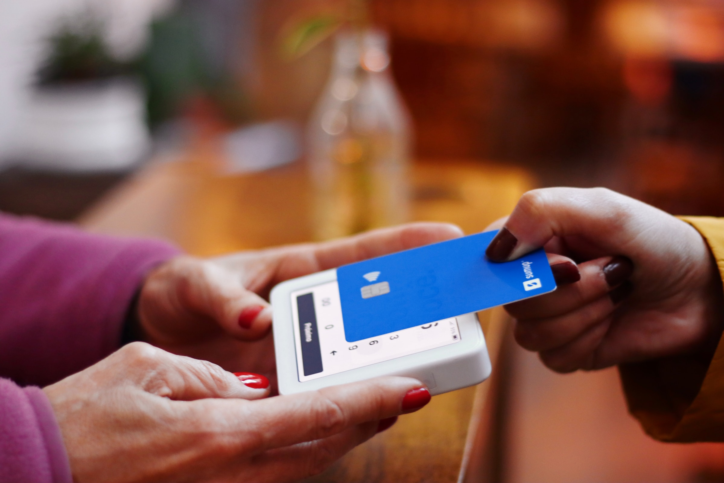Eine Nahaufnahme einer Frau, die ihre Rechnung mit einer Bankkarte bezahlt | Quelle: Unsplash