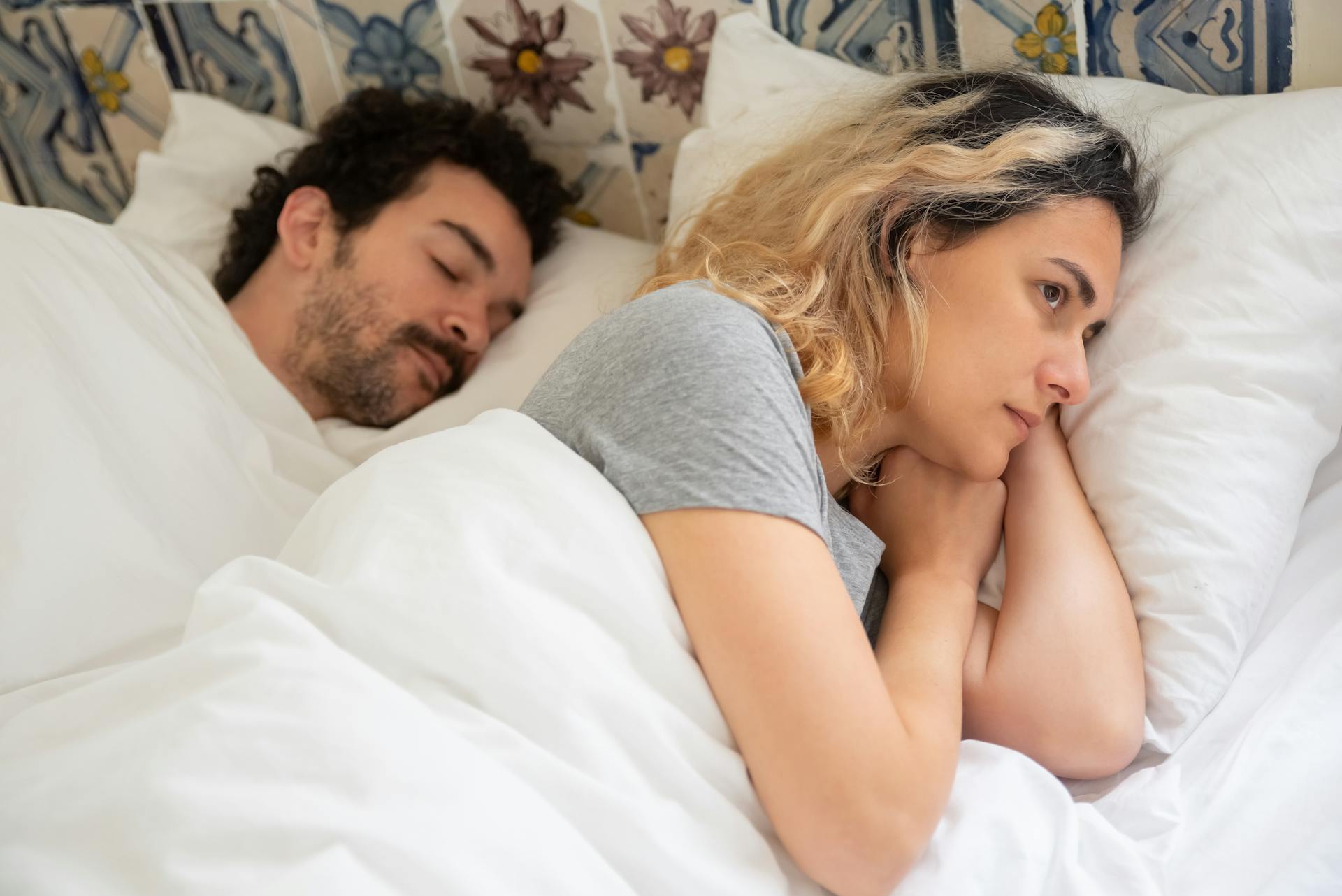 Eine nachdenkliche Frau, die wach im Bett liegt | Quelle: Pexels