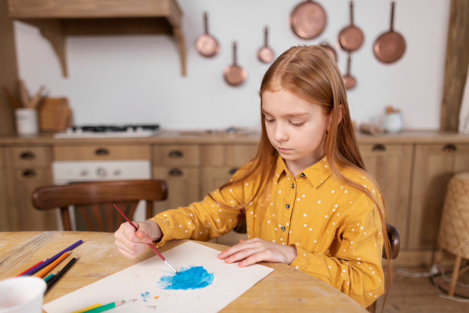 Ein Mädchen malt auf einem Blatt Papier | Quelle: Freepik